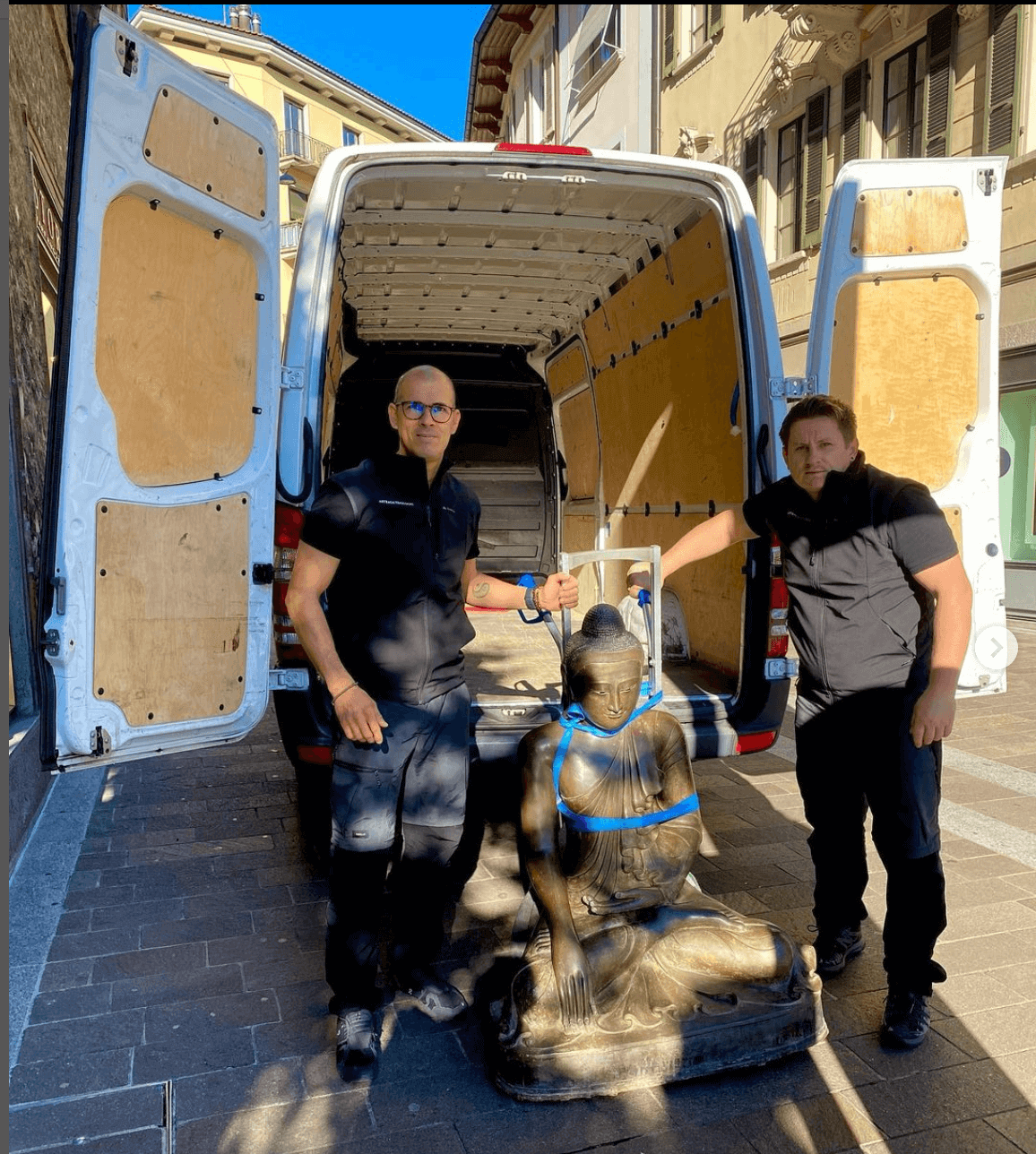 Equipe di Arteaga Traslochi pronta per caricare una statua gigante sul camion. La statua rappresenta un Buddah
