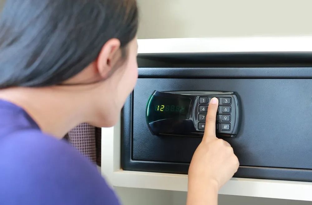 Woman Presses Buttons on a Black Safe With a Digital Display, Likely Entering a Code — CTS Locksmiths in Maroochydore, QLD
