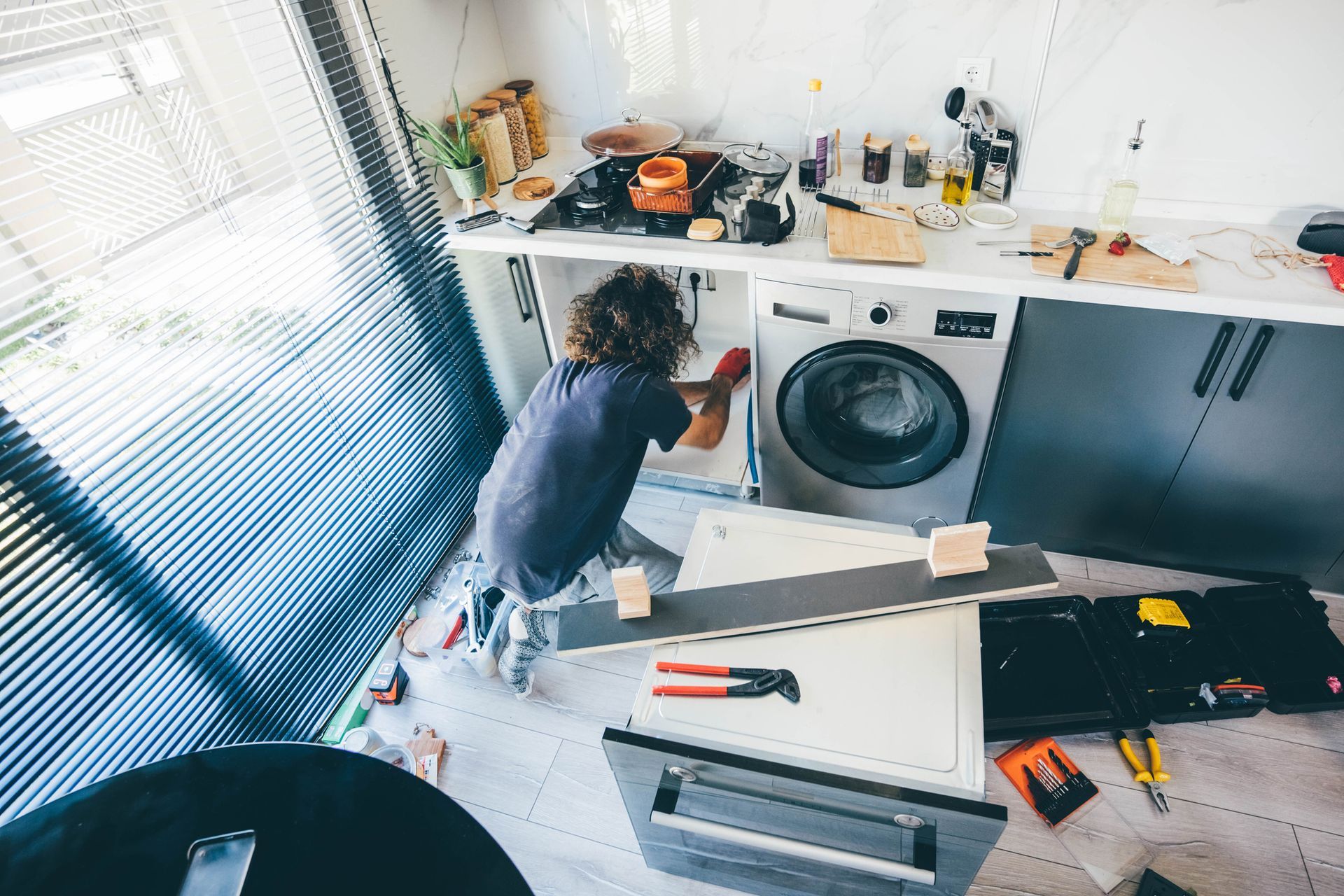 A man repairing a washing machine.