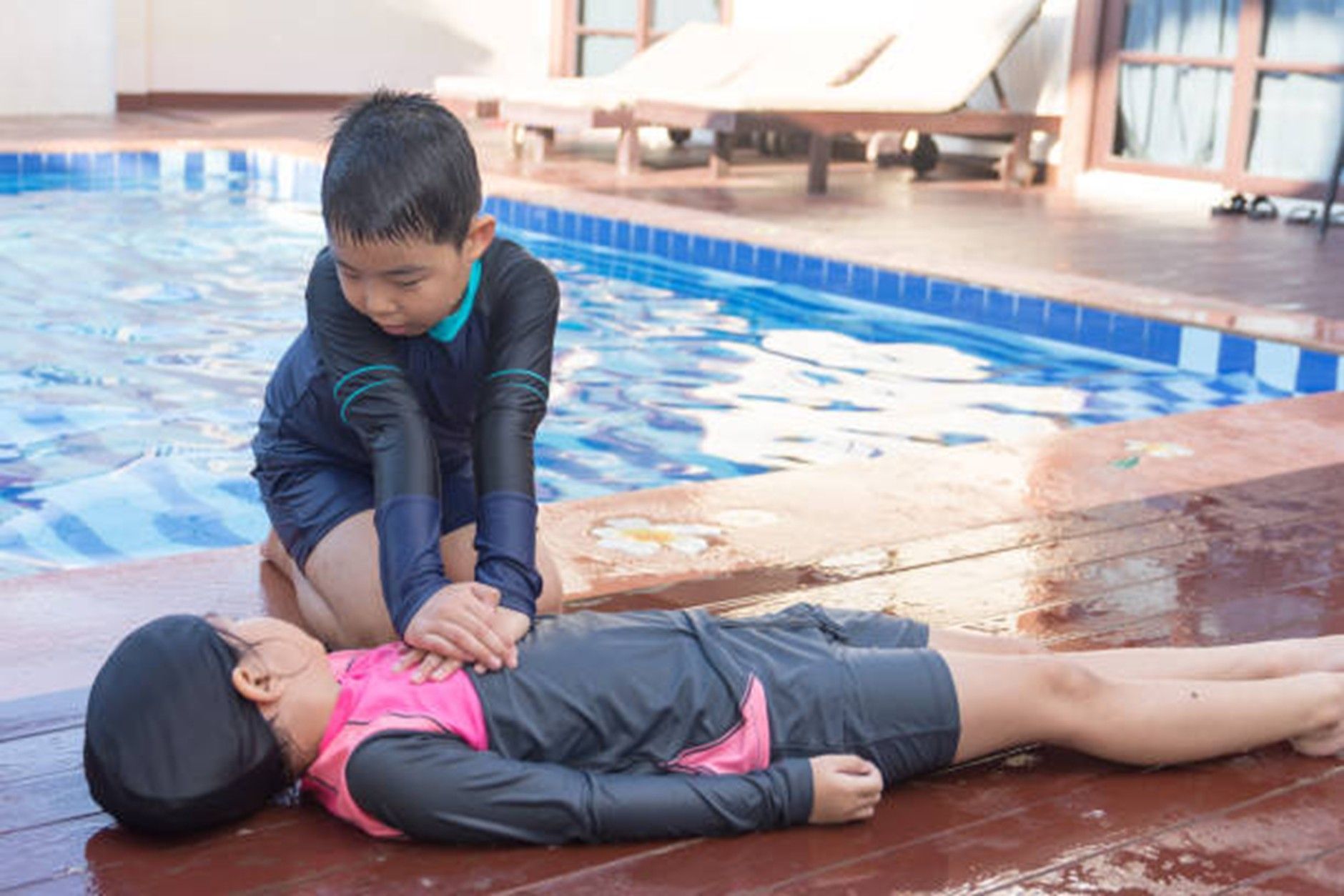 child doing CPR on another child