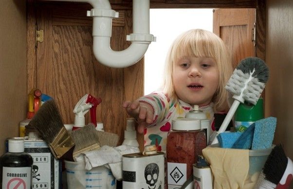 child in cupboard under the sink where poisons are held