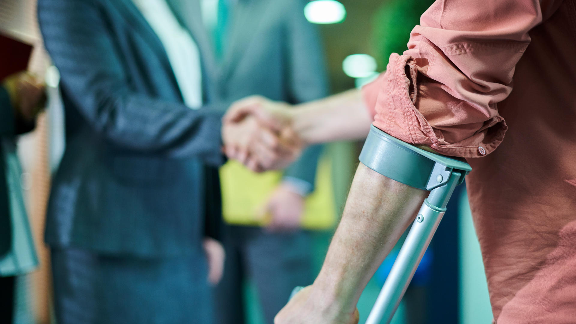 A man with crutches is shaking hands with a woman.