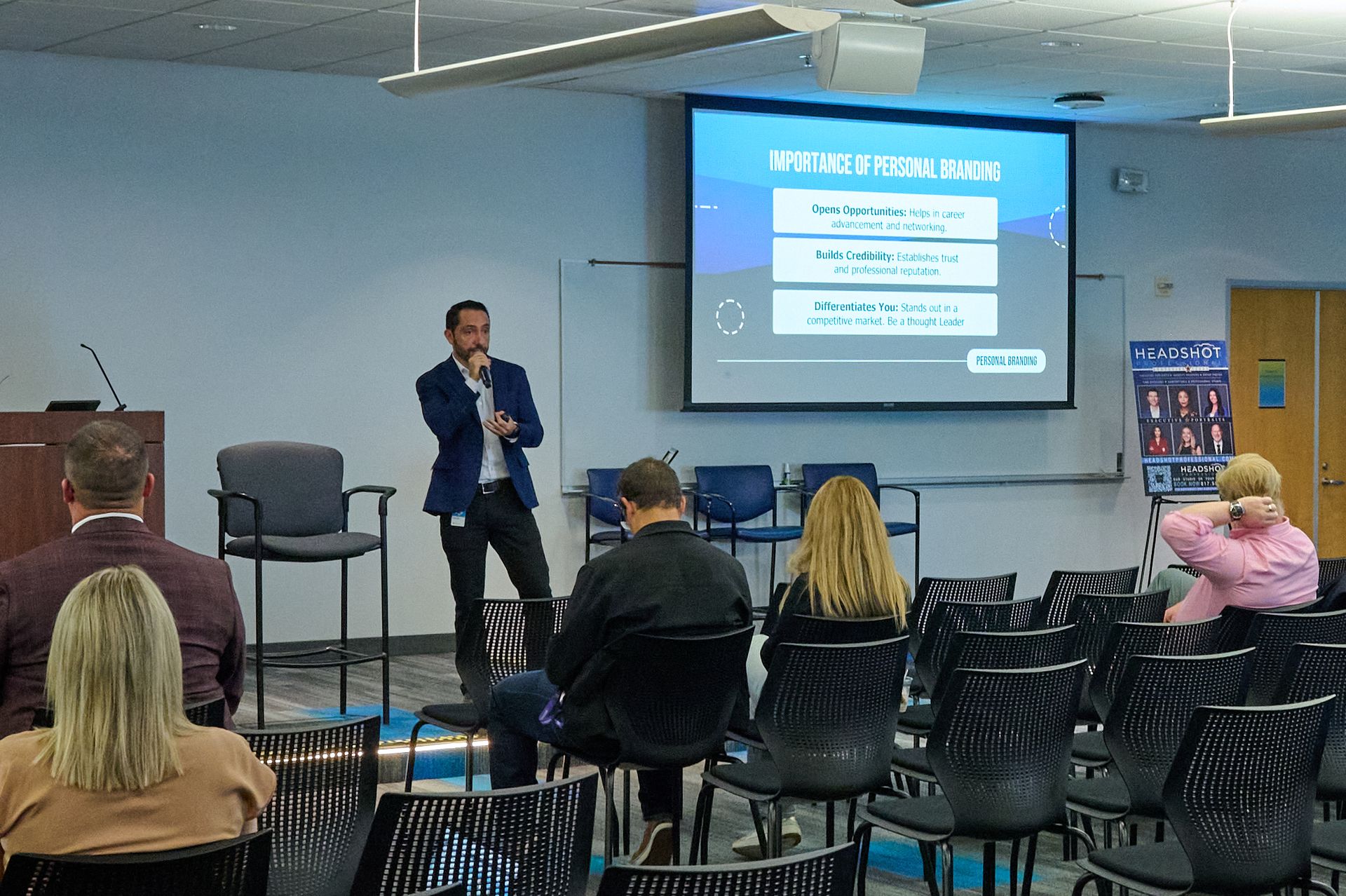 A man is giving a presentation to a group of people sitting in chairs.