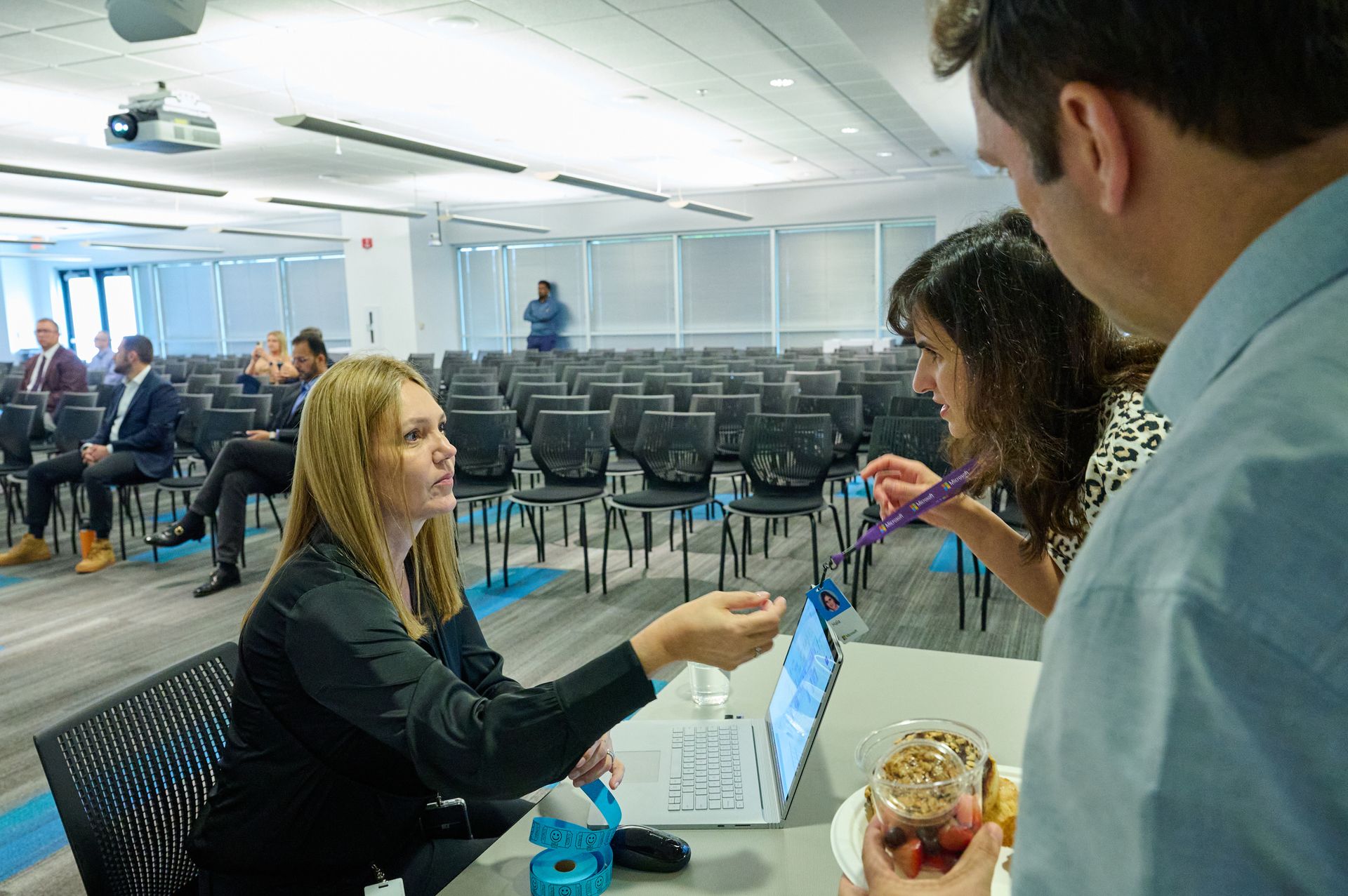 A group of people are standing around a table in a conference room.