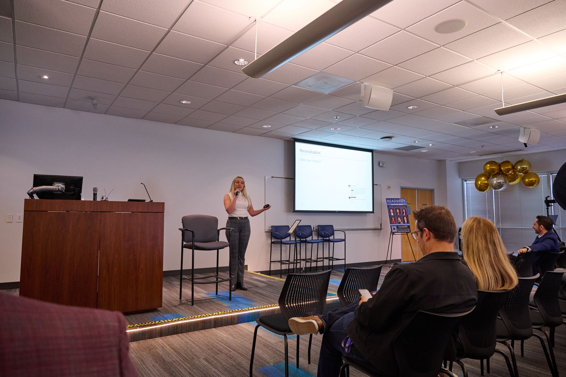 A woman is giving a presentation to a group of people in a conference room.
