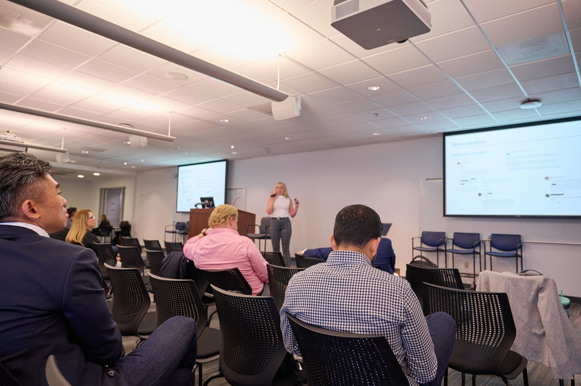 A woman is giving a presentation to a group of people in a conference room.