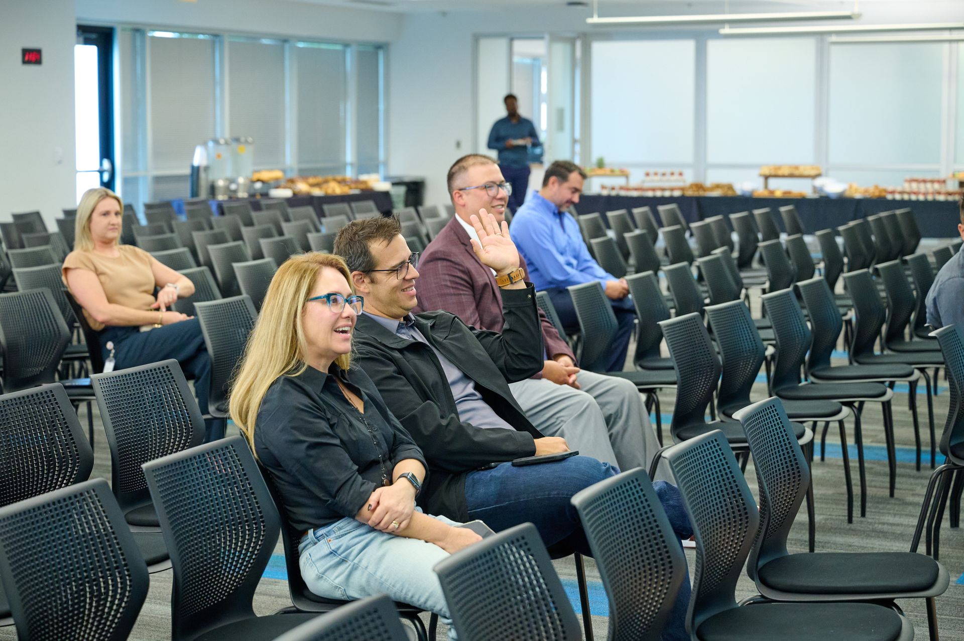 A group of people are sitting in chairs in a conference room.