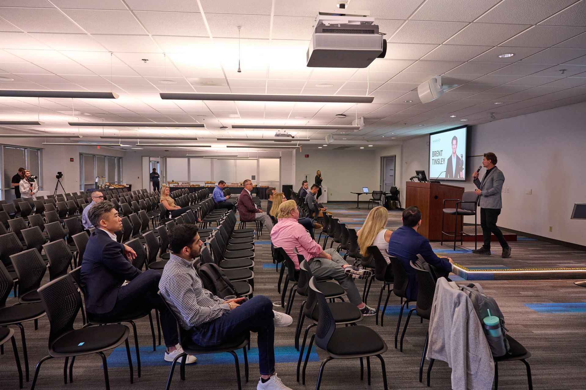A group of people are sitting in chairs in a large room.