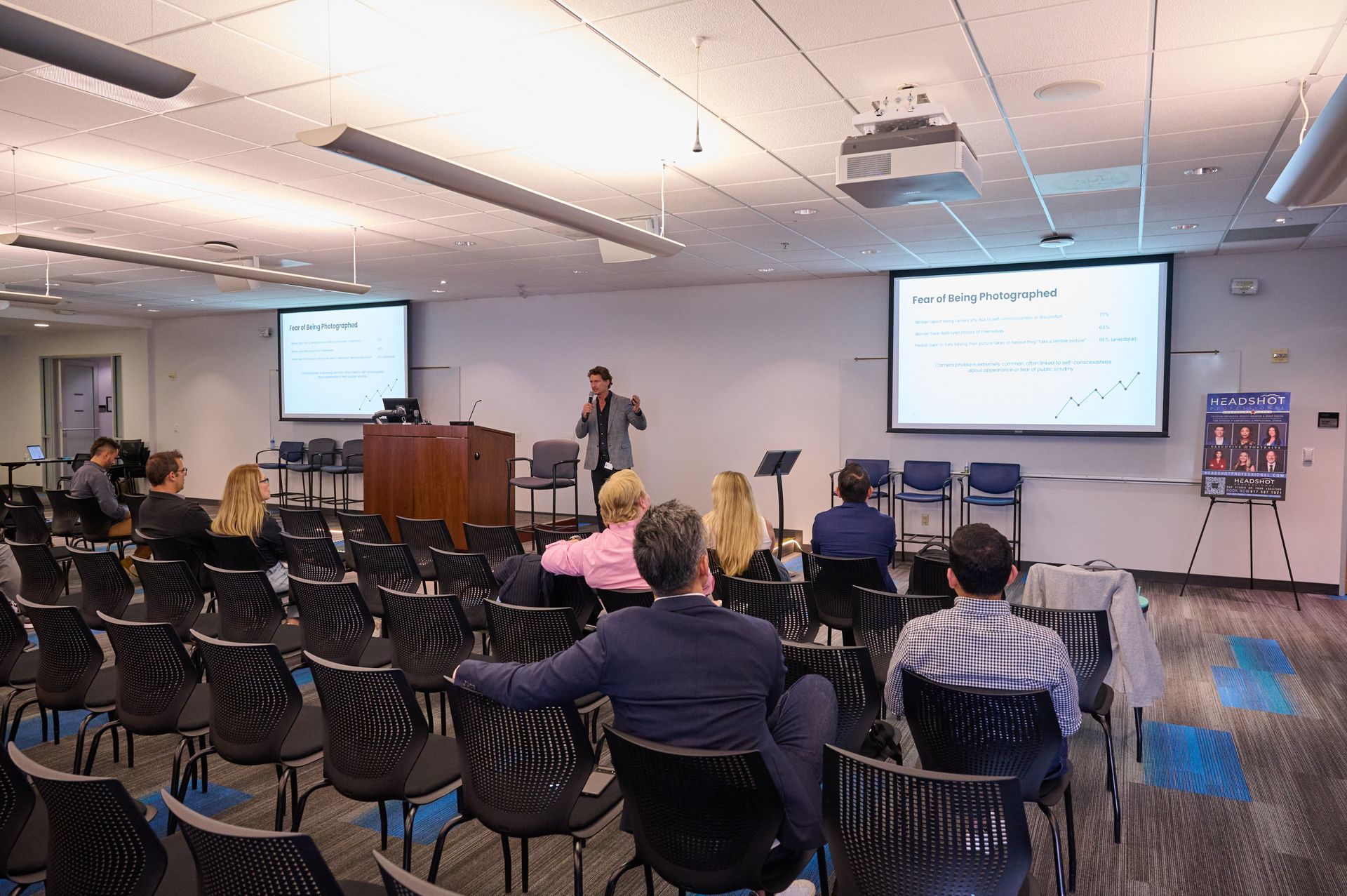 A man is giving a presentation to a group of people in a conference room.
