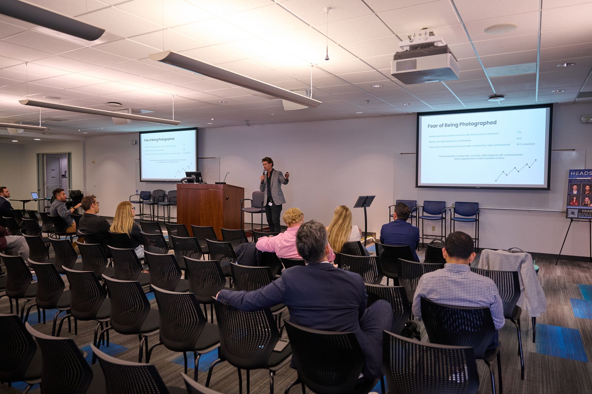 A woman is giving a presentation to a group of people in a conference room.