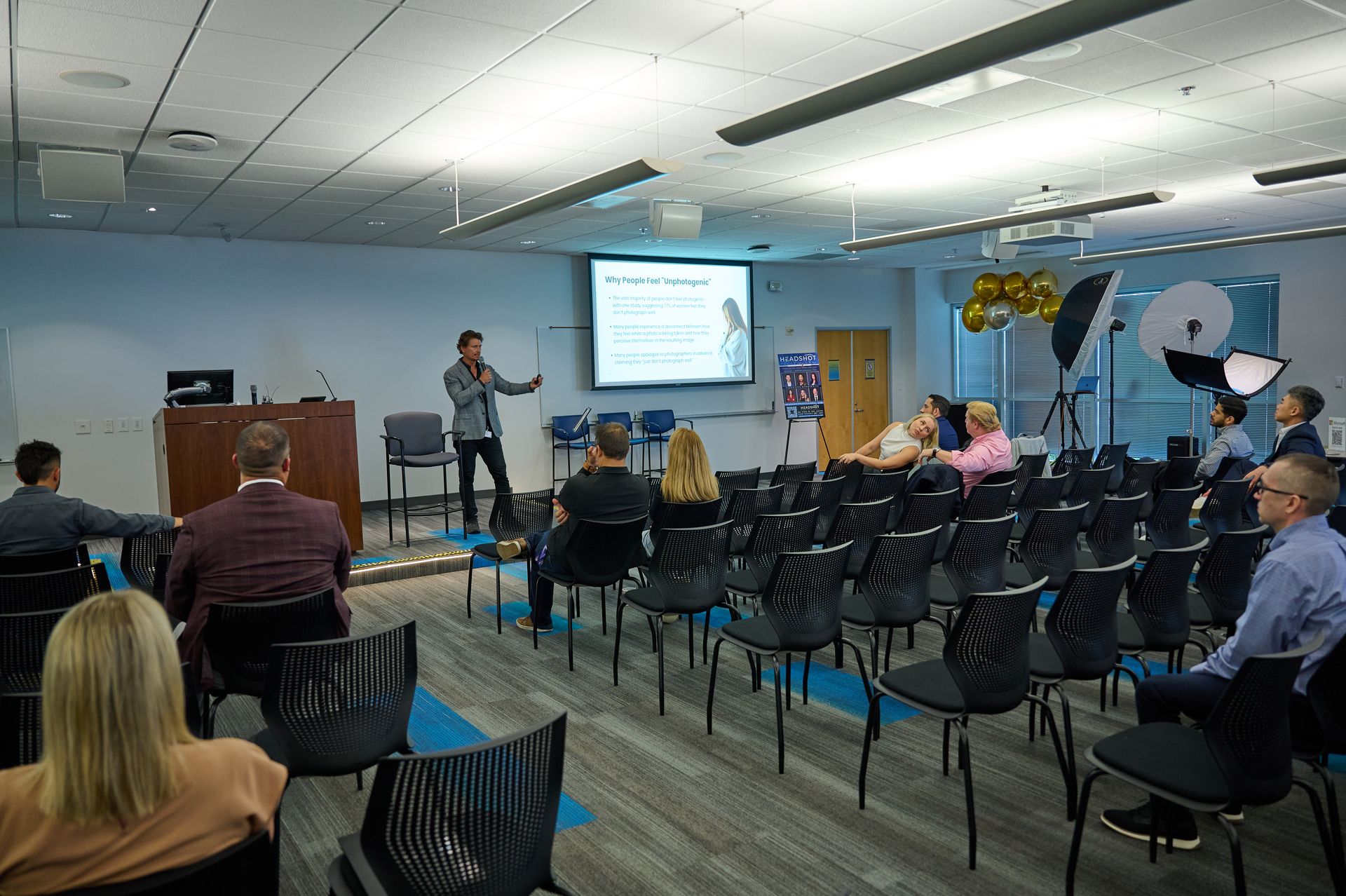 A man is giving a presentation to a group of people in a conference room.