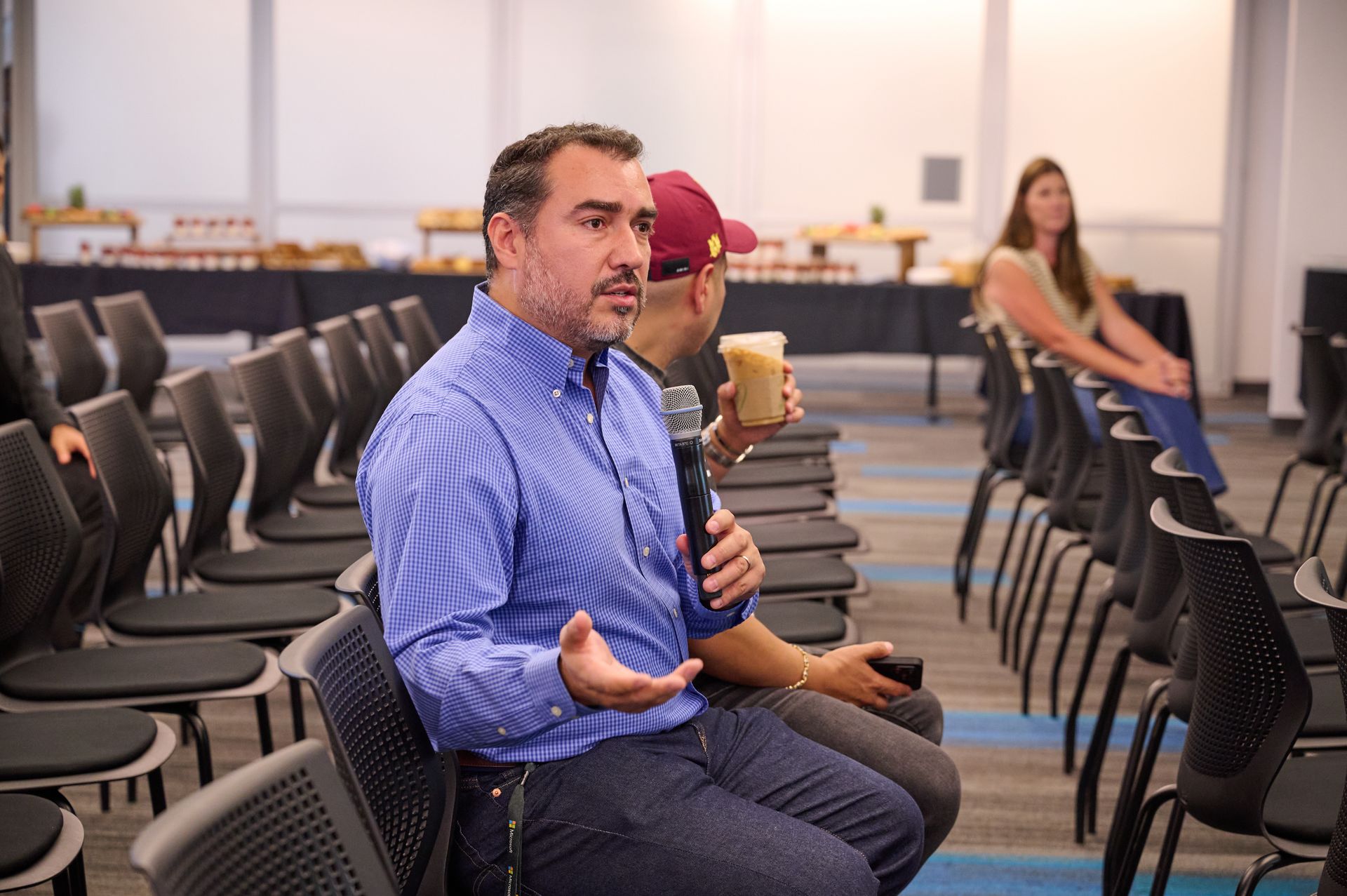A man is sitting in a chair holding a microphone.