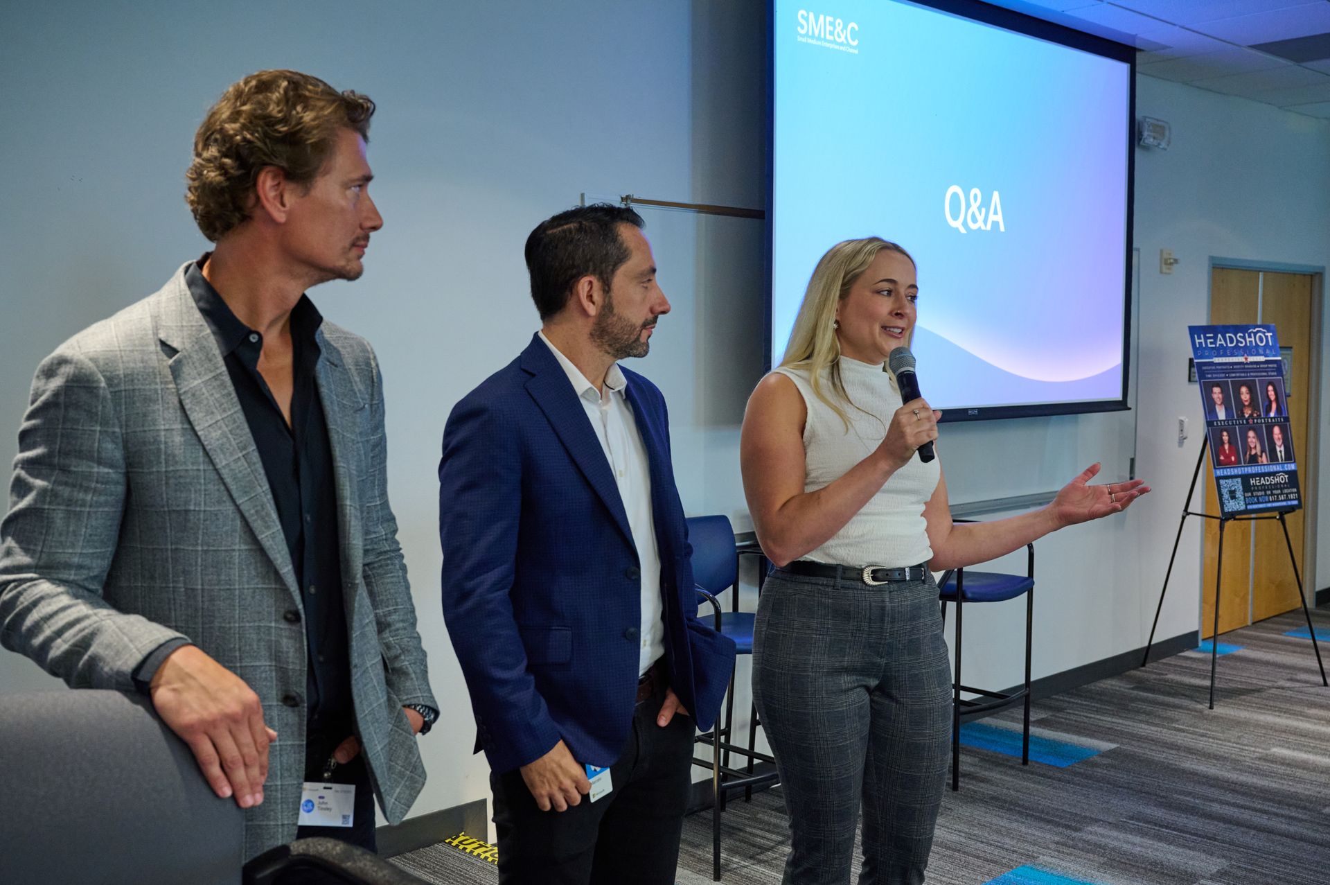 A group of people are standing in front of a projector screen.