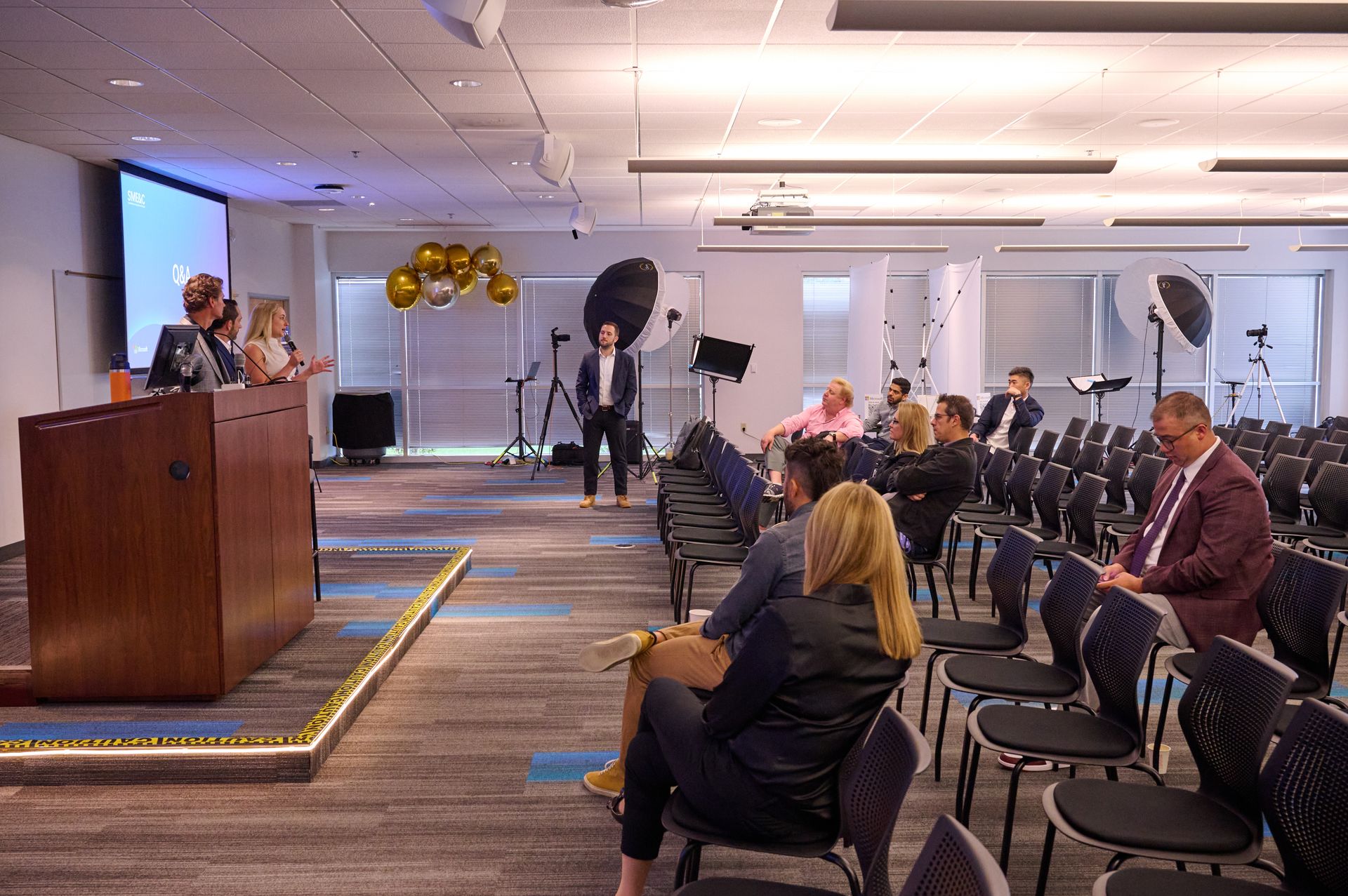 A group of people are sitting in chairs in a conference room.