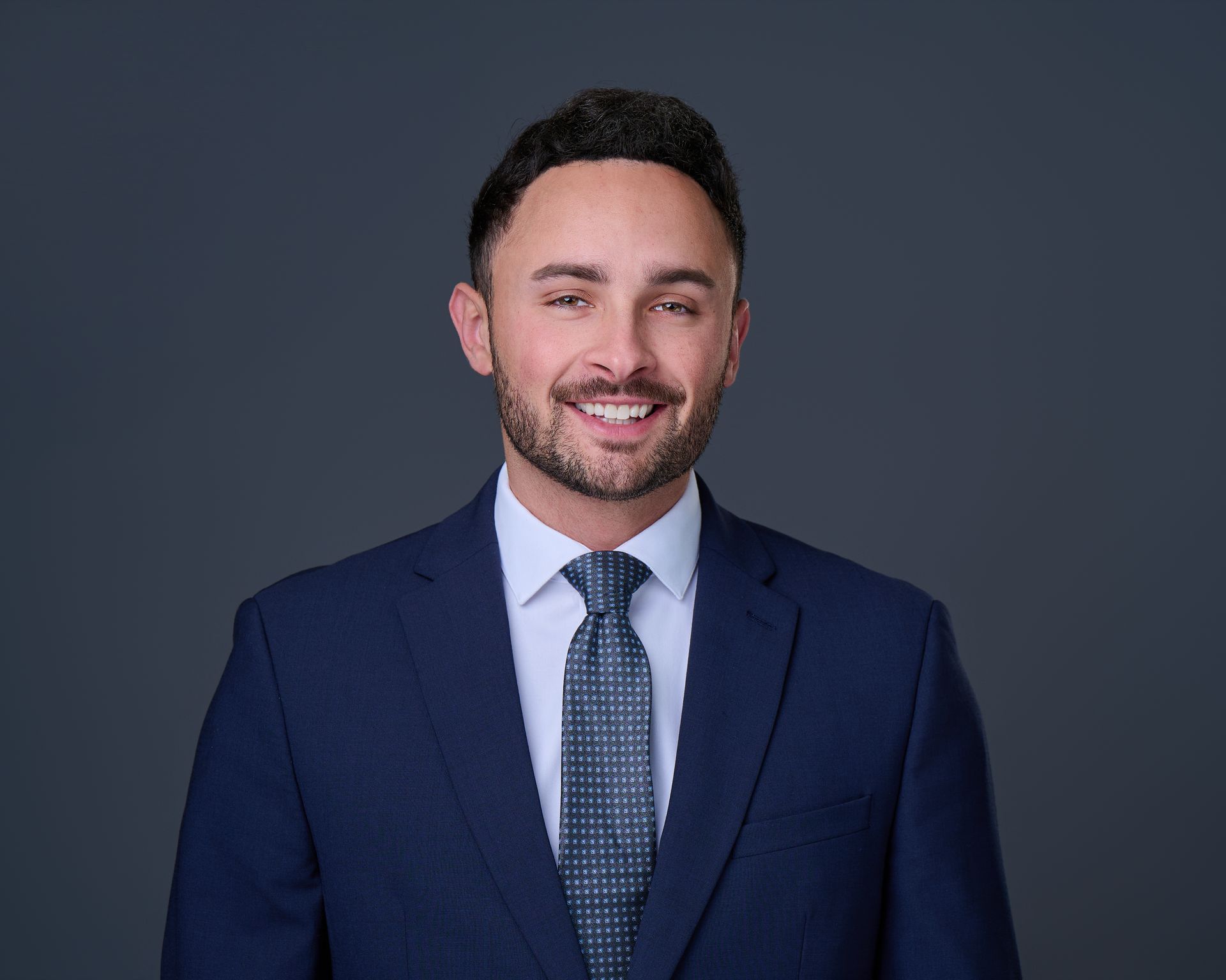 A man in a suit and tie is smiling for the camera.