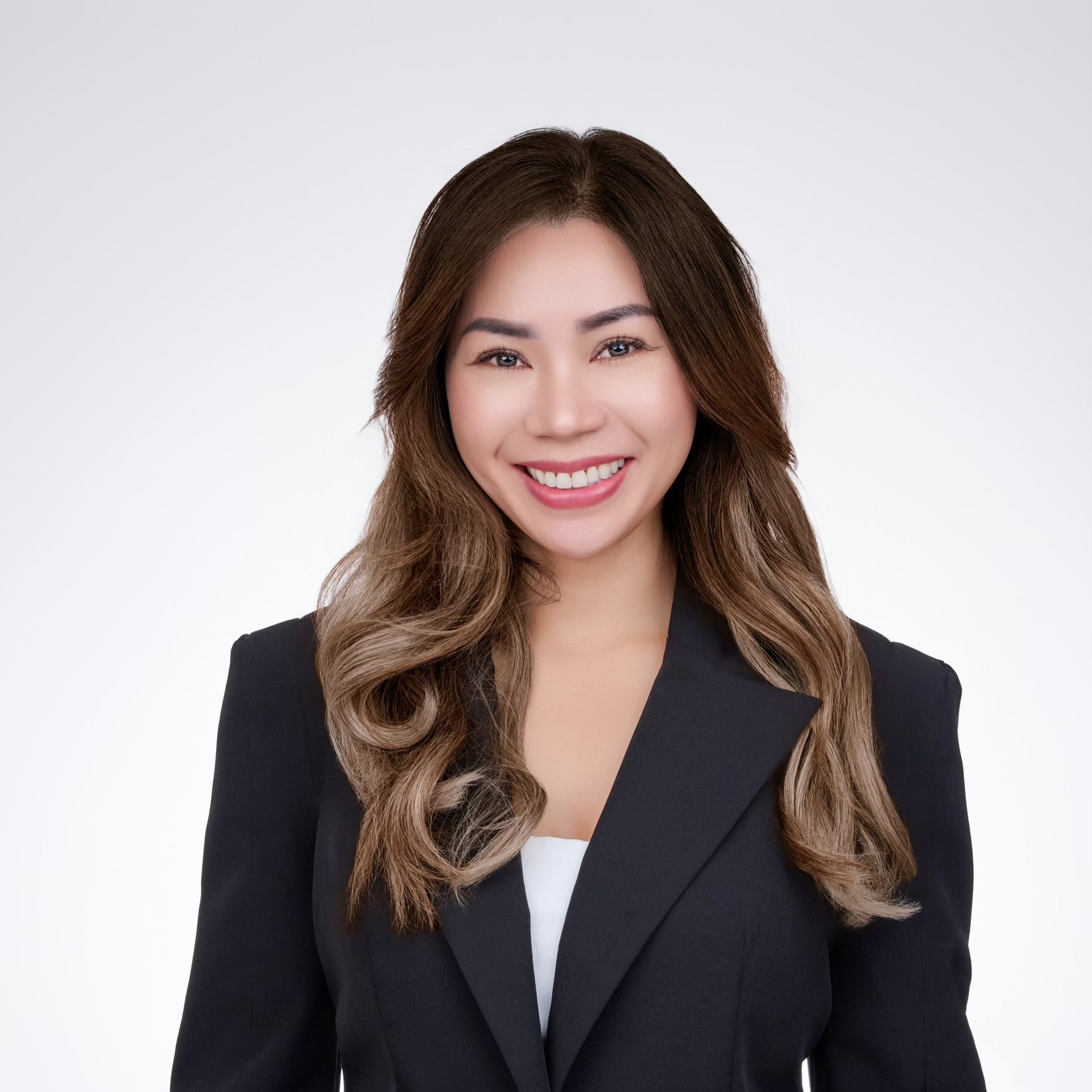 A woman in a black jacket is smiling for the camera