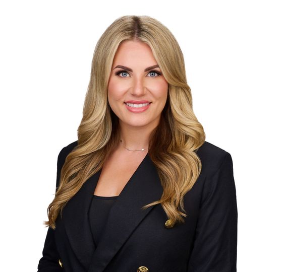 Professional headshot of a smiling woman in a black blazer against a white background