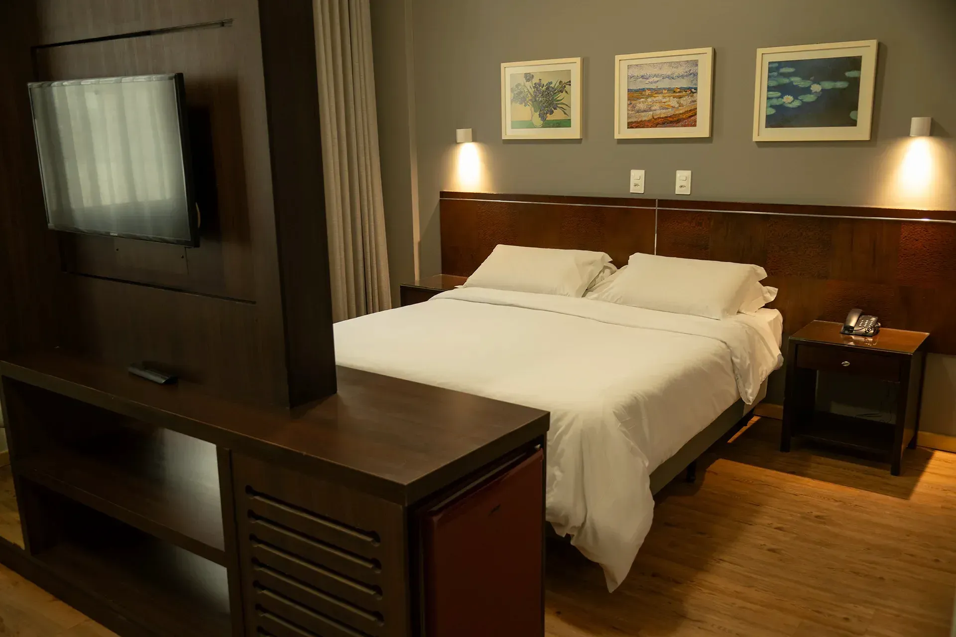 Um quarto de hotel com uma cama king size e uma TV de tela plana