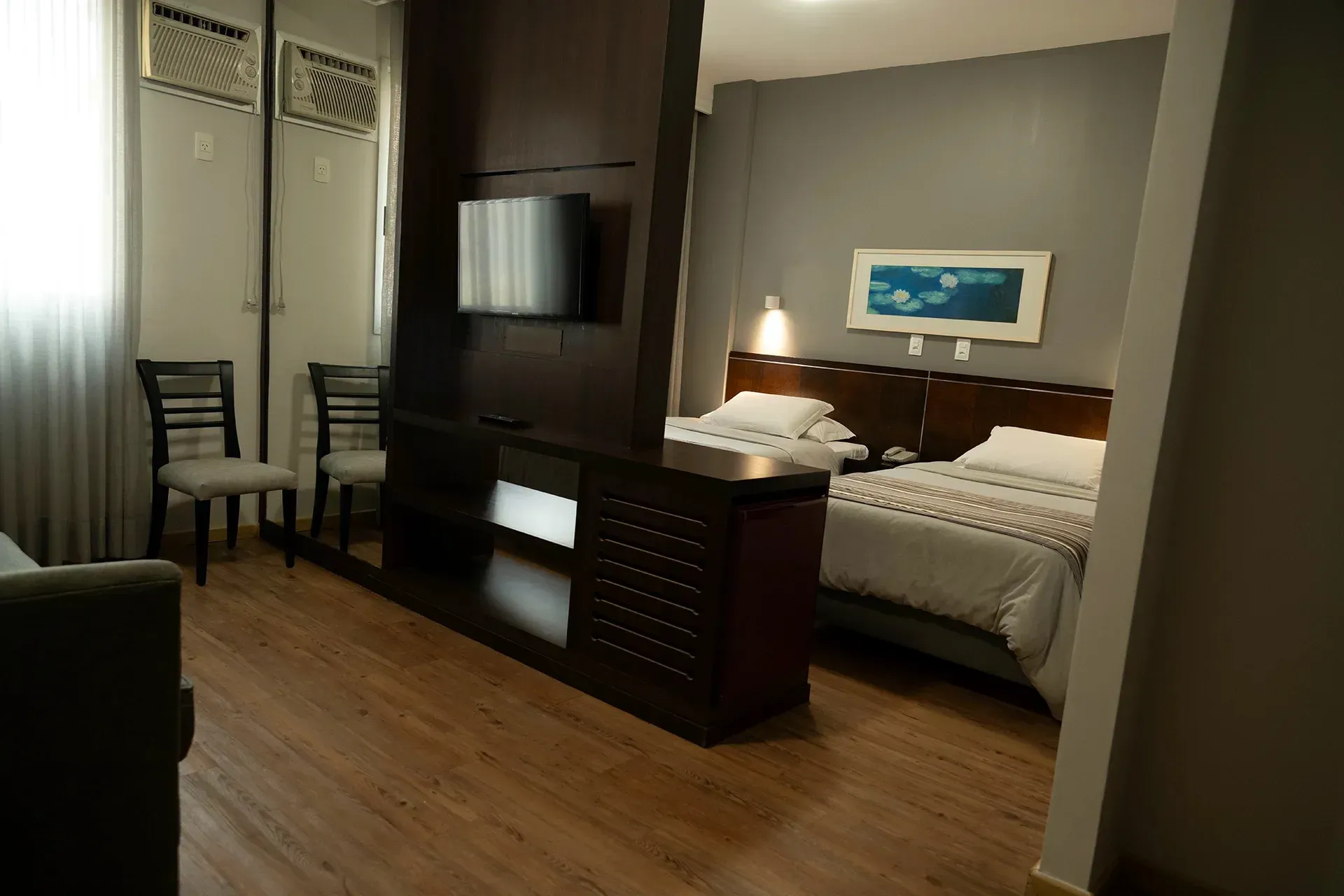 Um quarto de hotel com uma cama e uma TV de tela plana