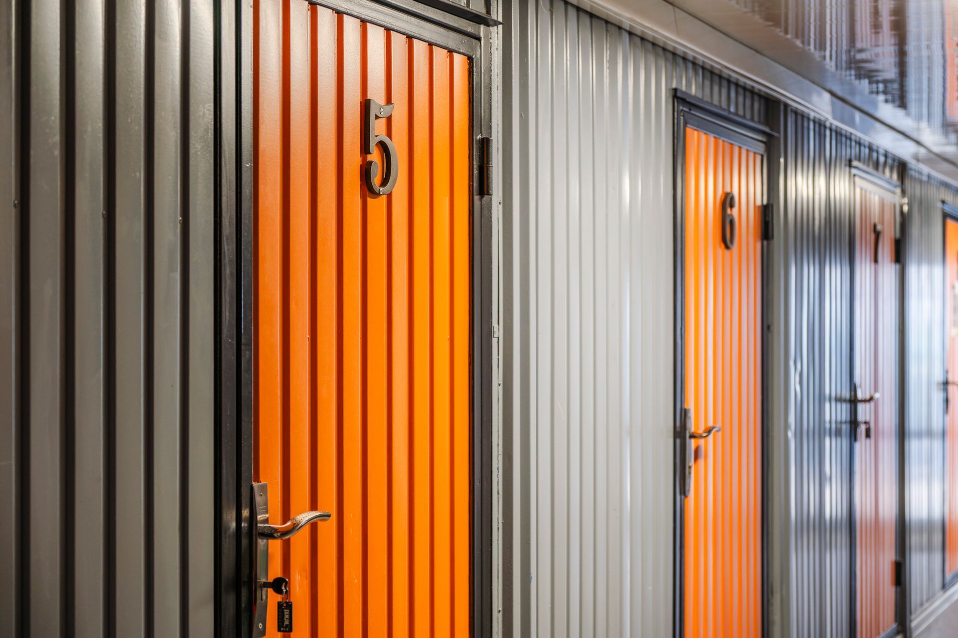 Rows of mini storage rental units inside a facility.