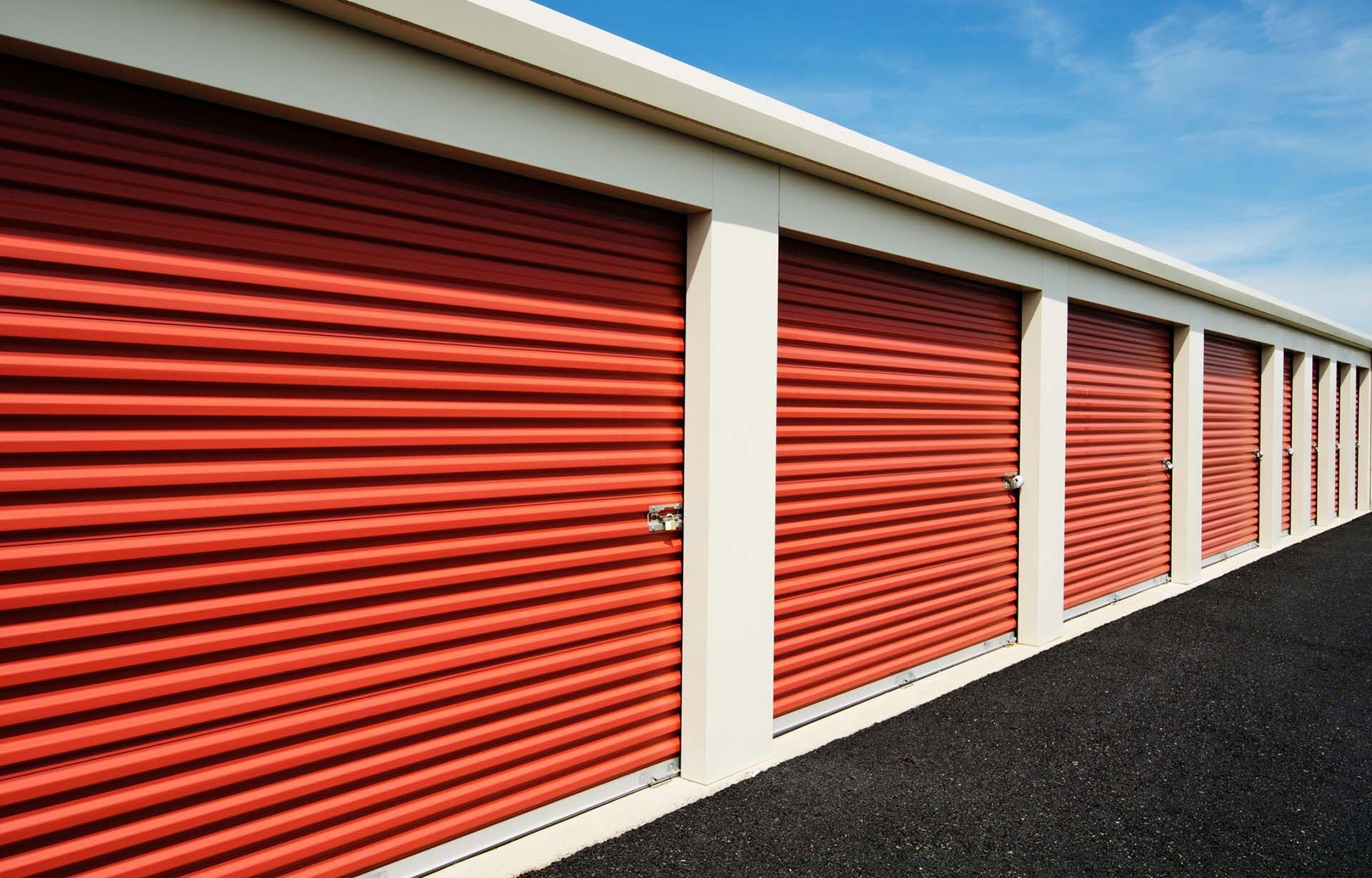 Row of red storage unit doors at outdoor self storage facility. Row of red storage unit doors at outdoor self storage facility.