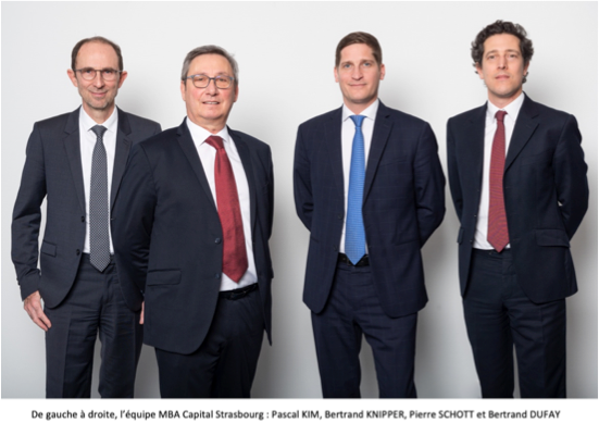 Quatre hommes en costume-cravate posent pour une photo