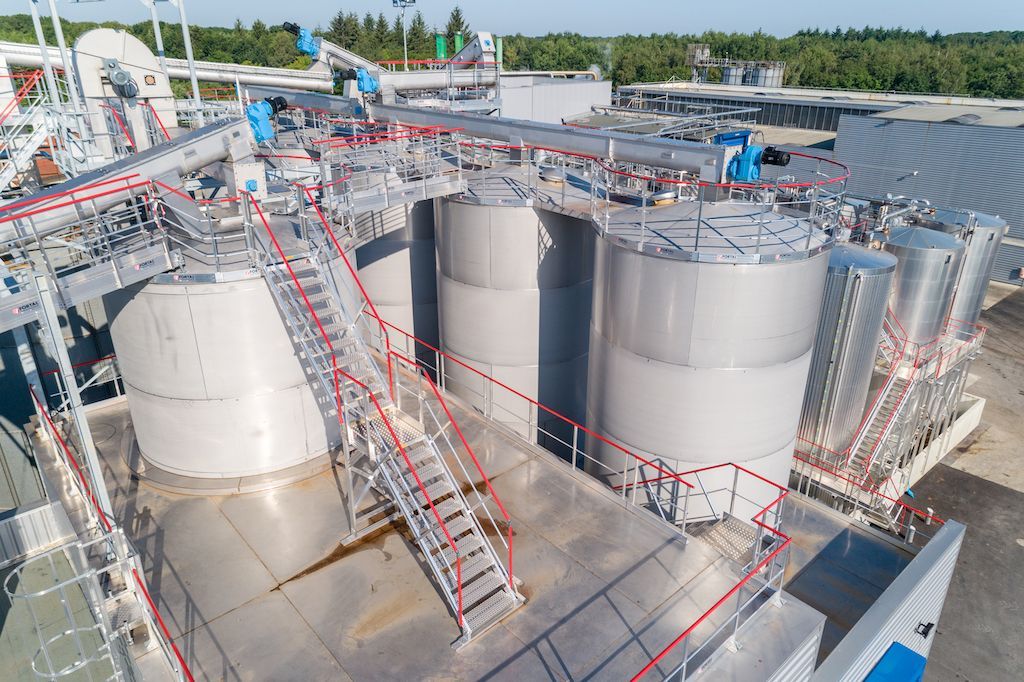 Une vue aérienne d'une usine avec beaucoup de réservoirs et d'escaliers.