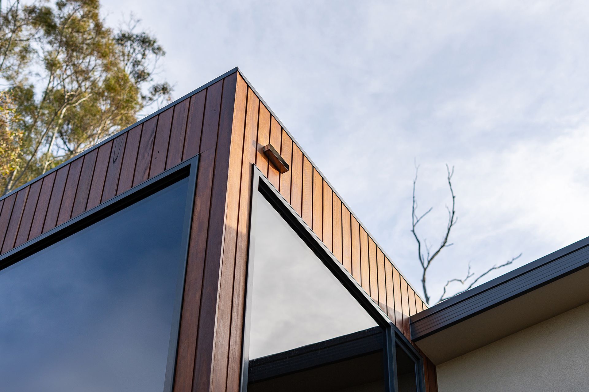 A close up of the roof of a house with a tree in the background.