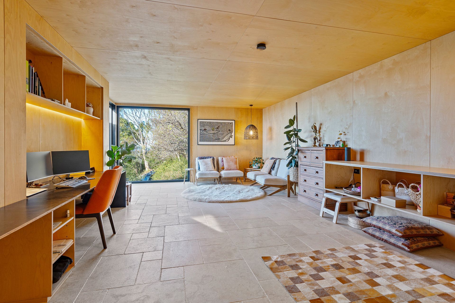 A living room with a couch , chairs , a desk and a rug.