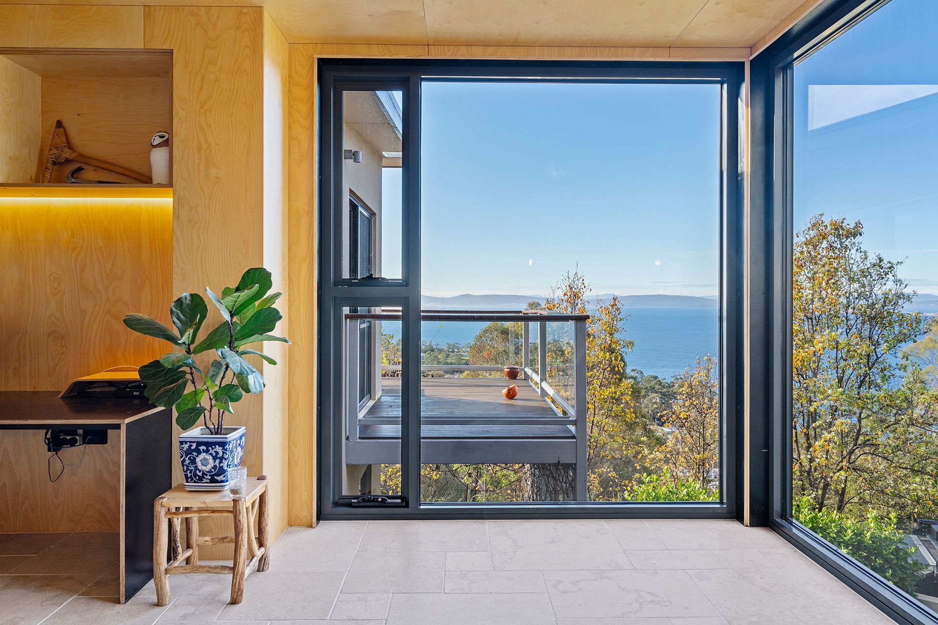 A room with a lot of windows and a view of the ocean.
