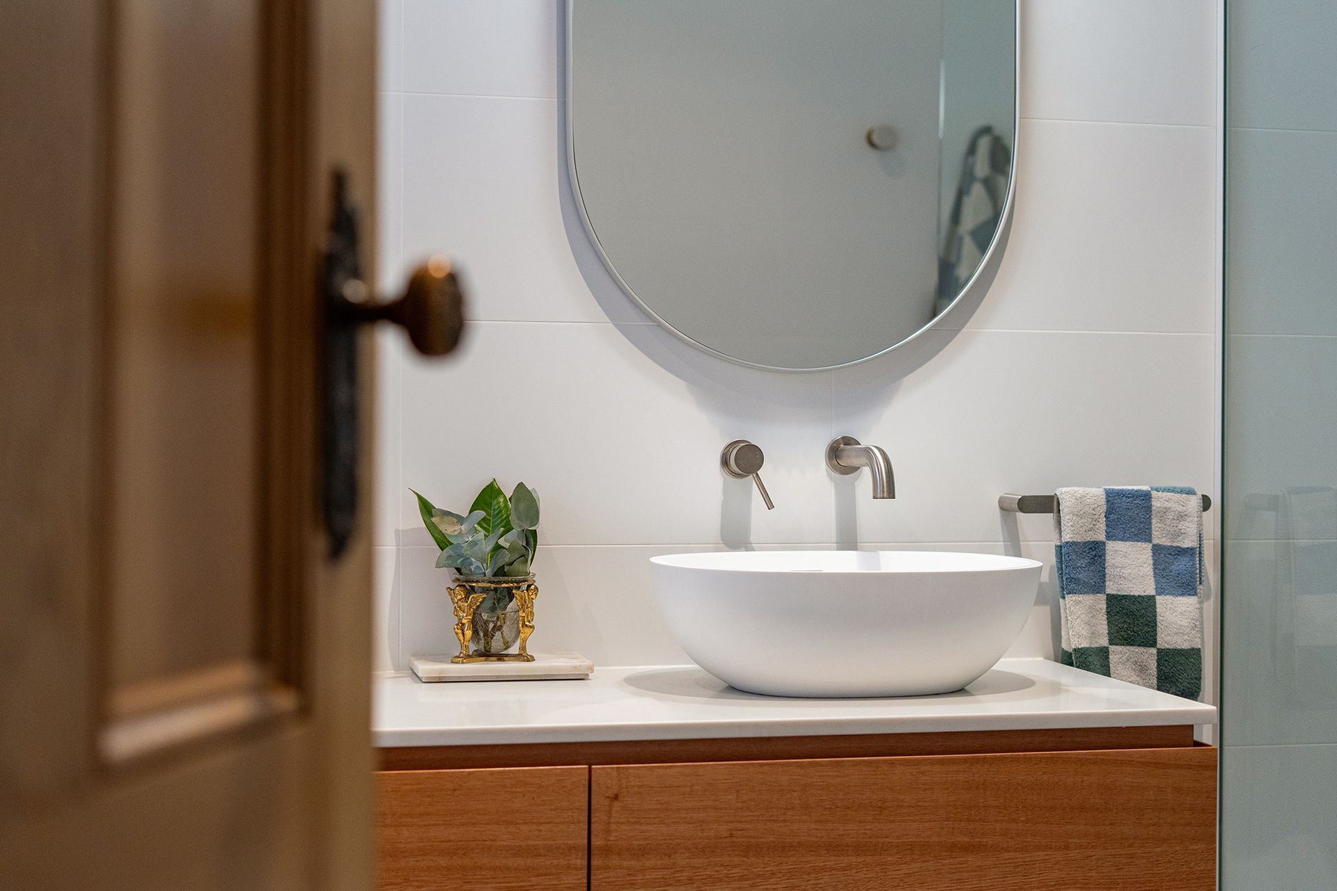 A bathroom with a sink , mirror and towel rack.