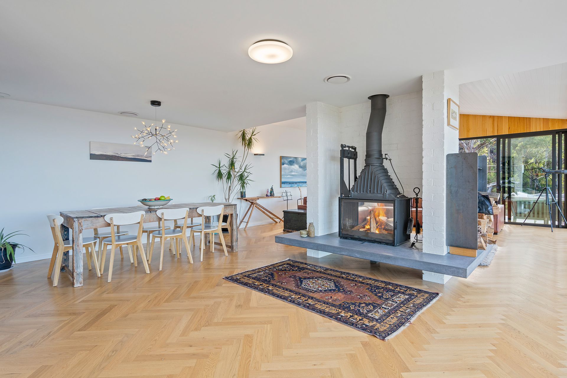 A living room with a fireplace , dining table and chairs.