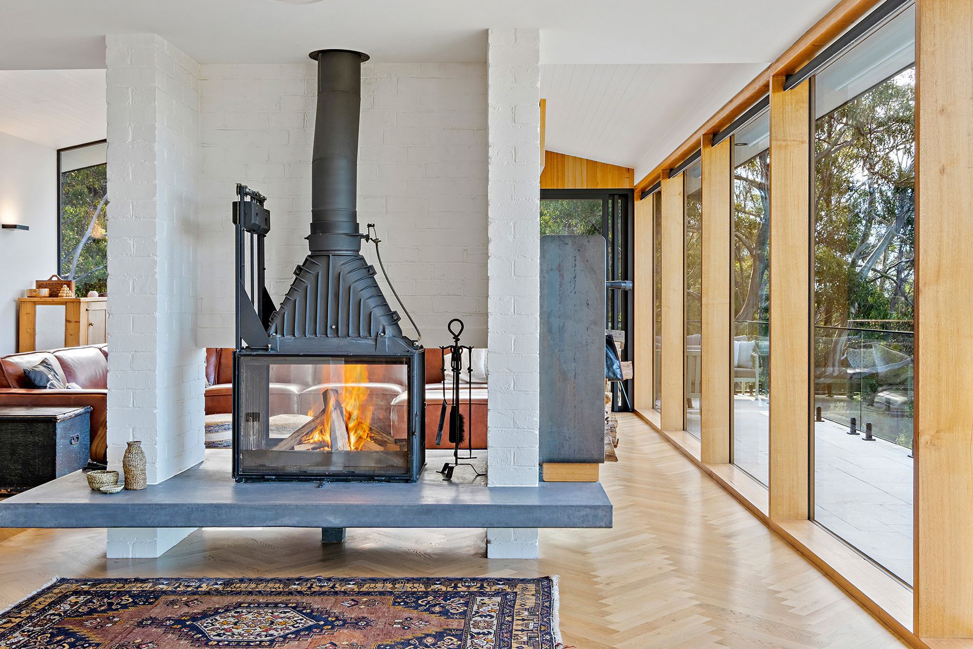 A living room with a fireplace and lots of windows