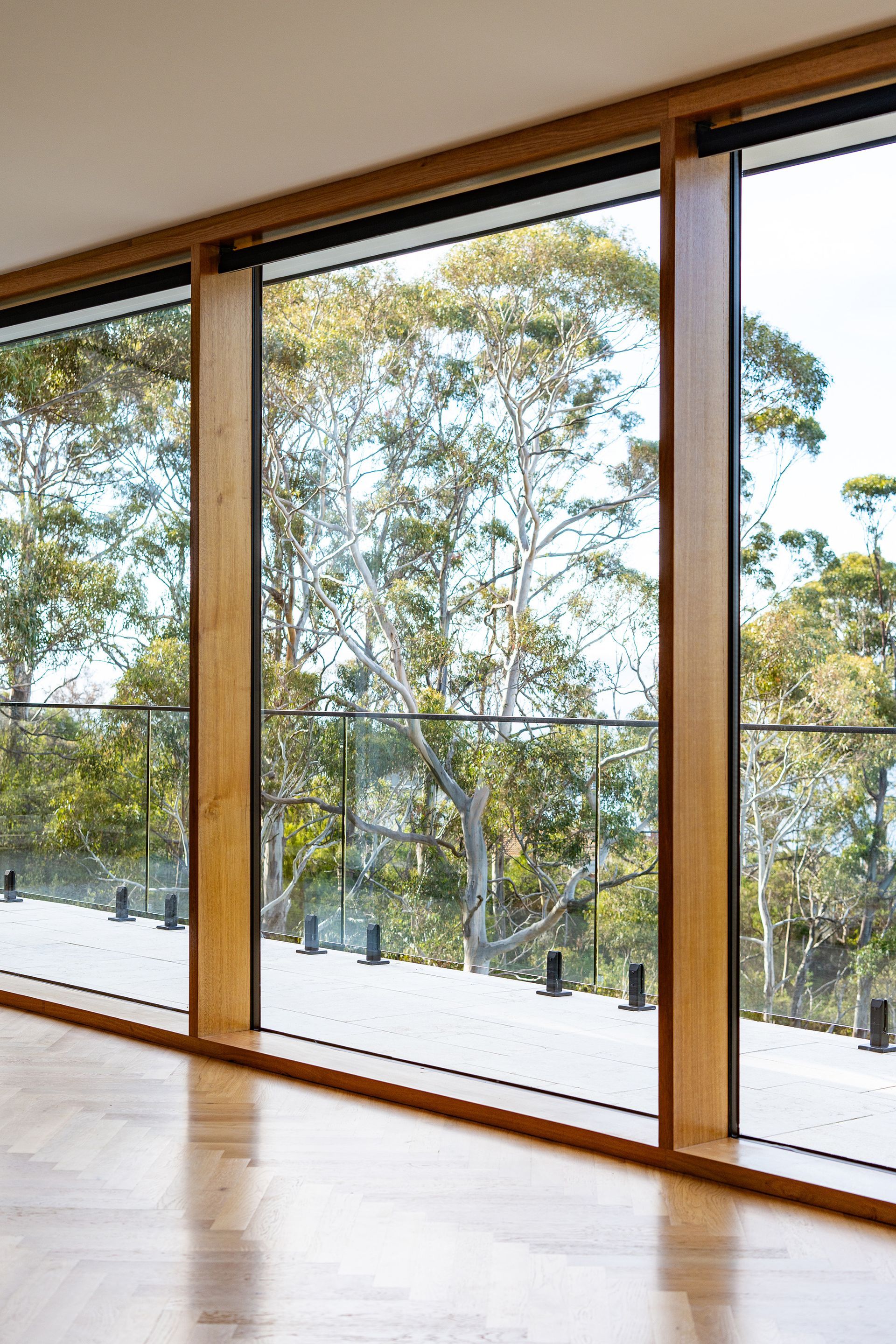 A room with a lot of windows and a view of trees.