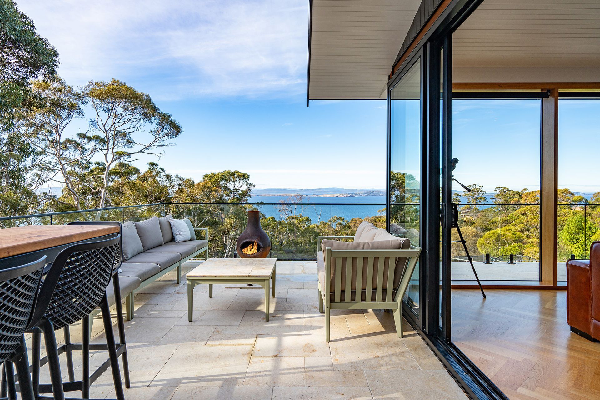 A patio with a fireplace and a view of the ocean