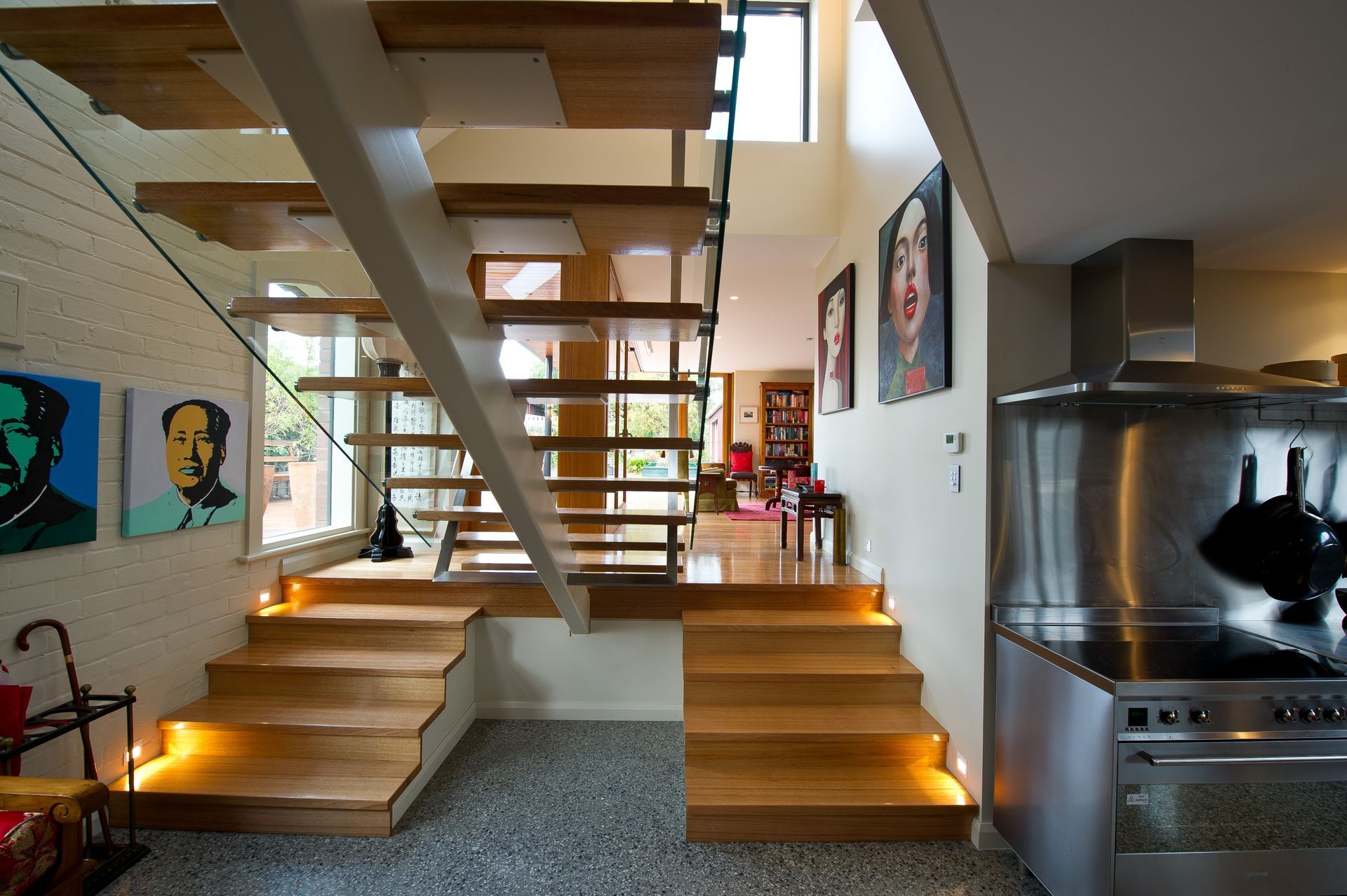 A kitchen with a stove and stairs leading up to the second floor