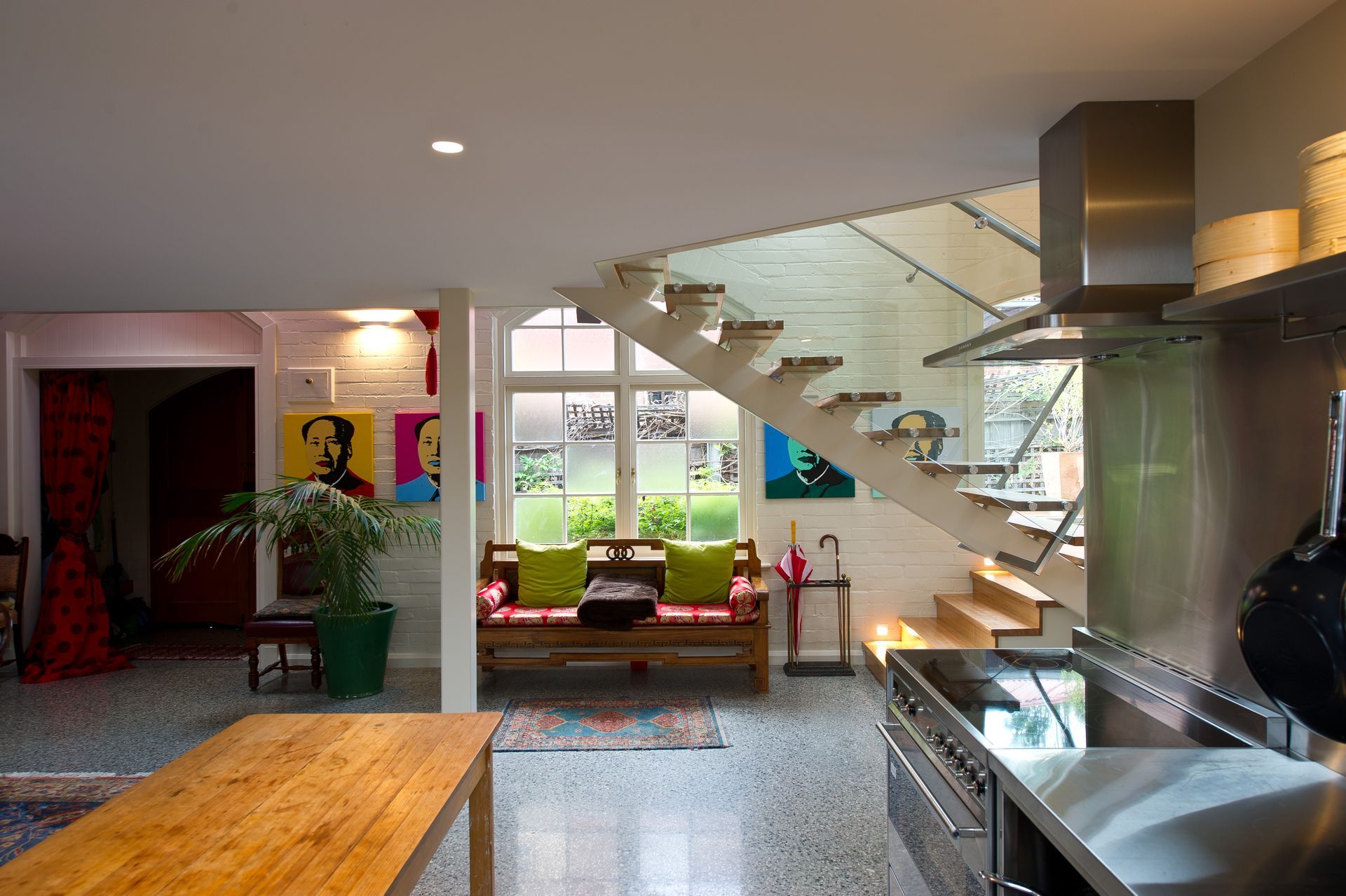 A kitchen with a wooden table and stainless steel appliances