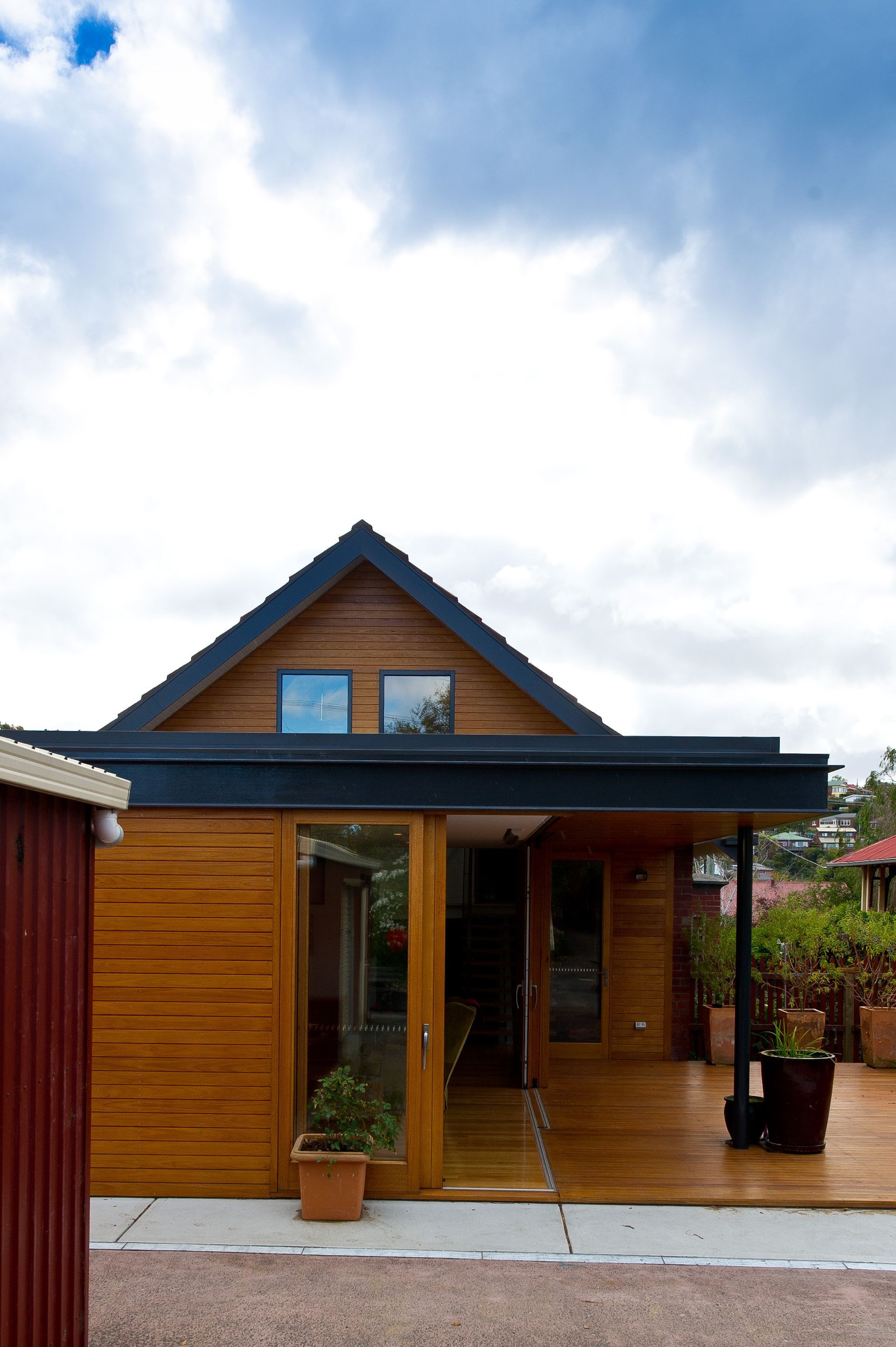 A wooden house with a blue roof and a sliding glass door
