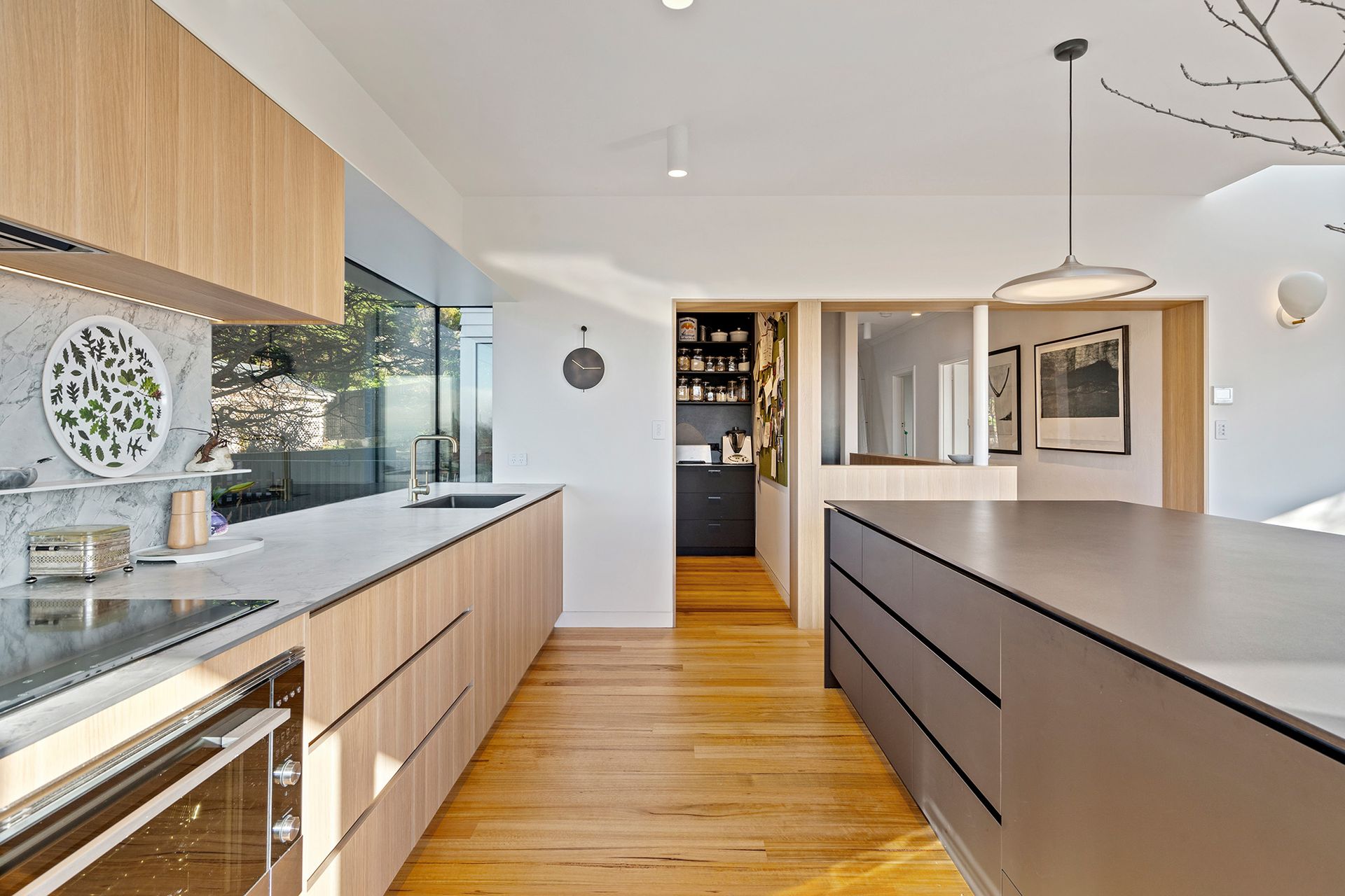 A kitchen with wooden cabinets and a large island in the middle.