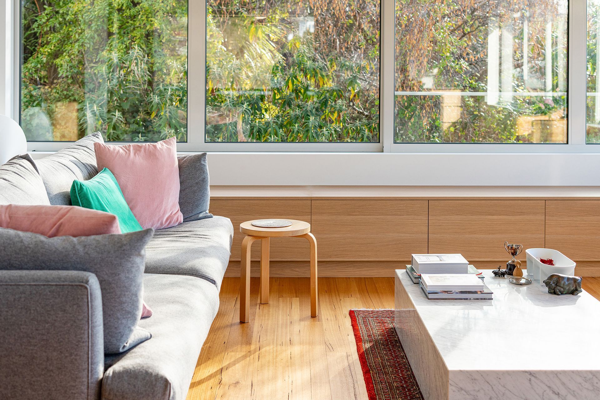 A living room with a couch , coffee table , and large window.