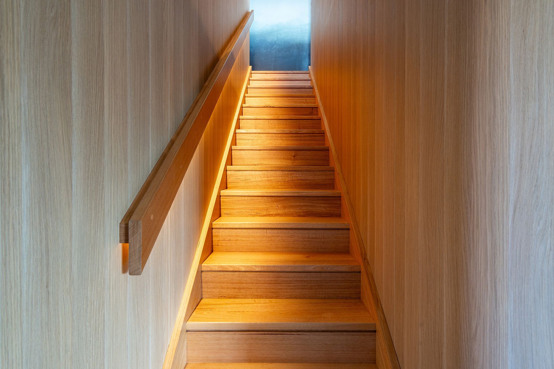 A set of wooden stairs leading up to the second floor of a house.