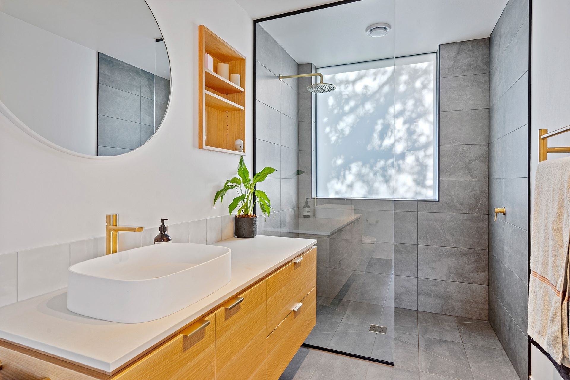 A bathroom with a sink , mirror , and walk in shower.