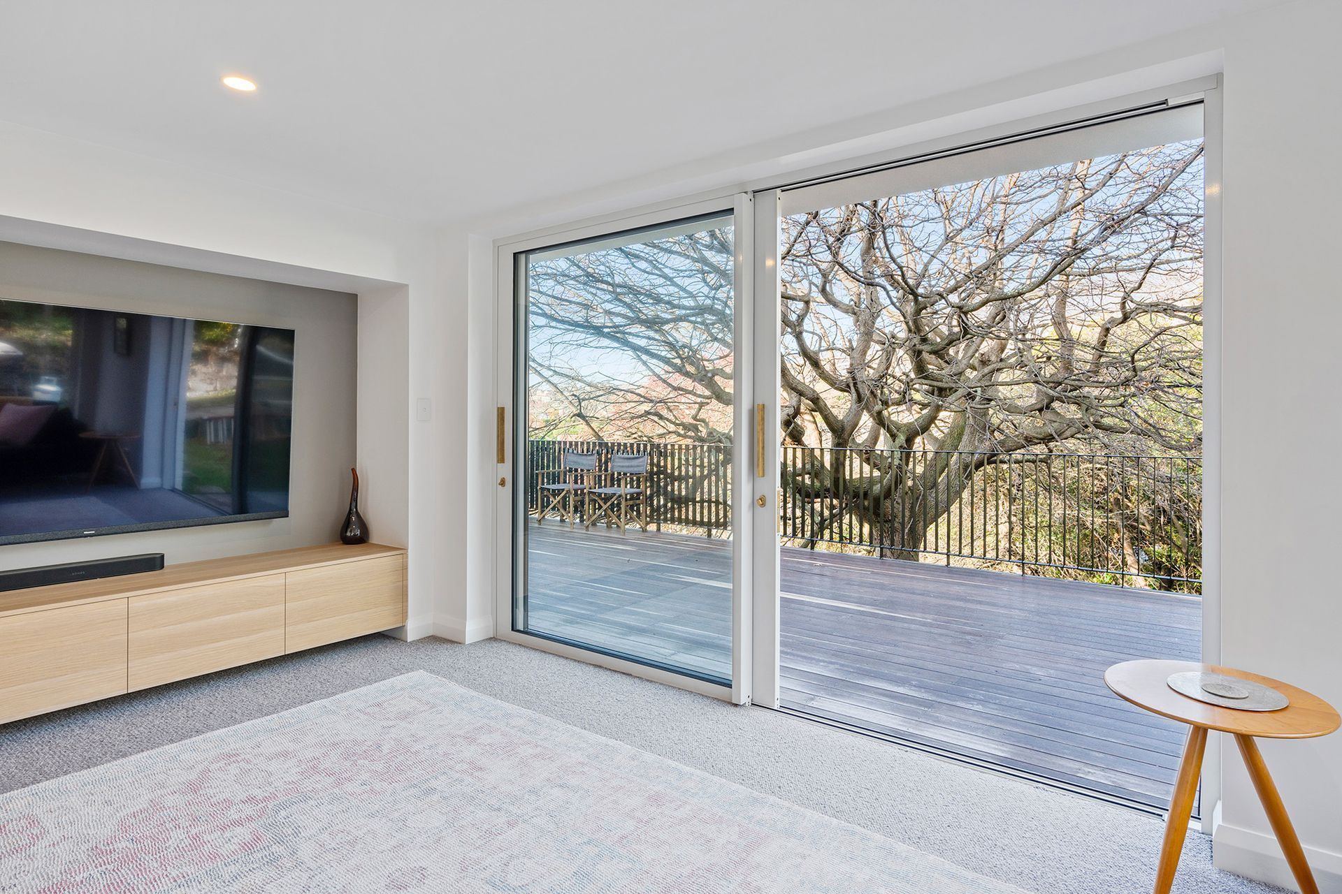 A living room with sliding glass doors and a flat screen tv.