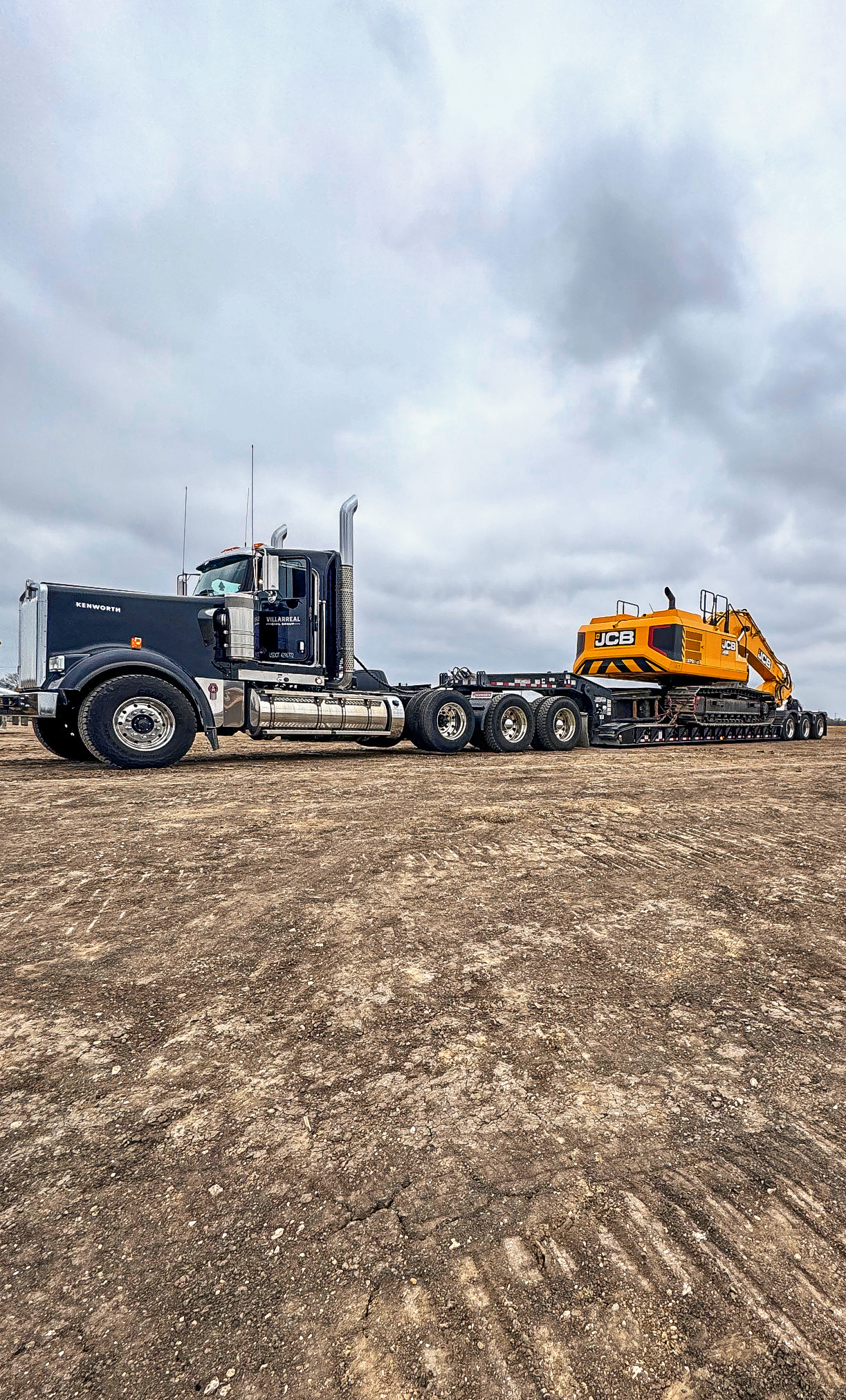A yellow excavator is loading dirt into a dump truck.