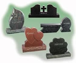 Assorted decorative headstones and memorial plaques in different shapes and colors on a white background