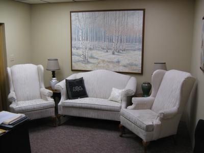 White living room seating set with sofa, two armchairs, lamps, and a large wall painting