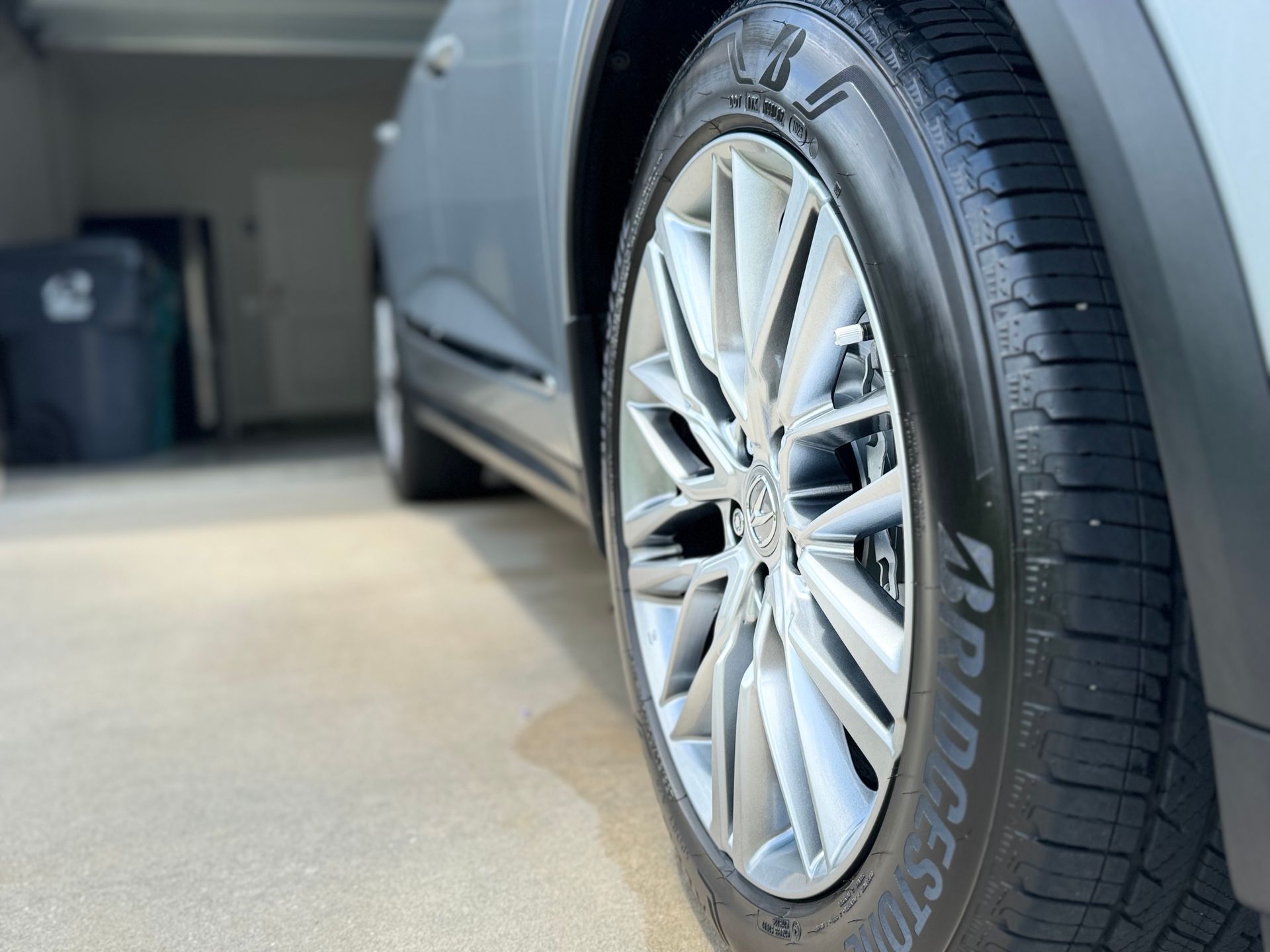 A close up of a tire on a car in a driveway.