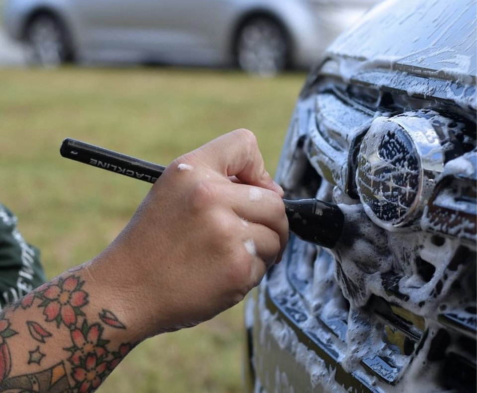 A green and white van is parked in front of a house.
