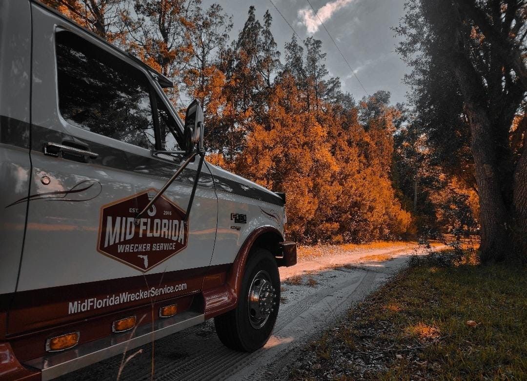 Truck parked on a dirt road. The truck has a logo that reads 