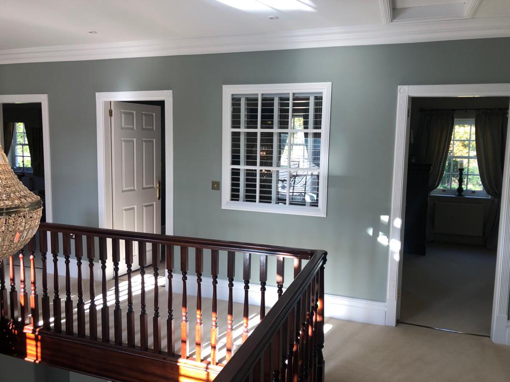 This is a picture of a stairs and landing that has been painted and decorated using soft grey pastel colours . This is a job done by Painters and Decorators Leicester